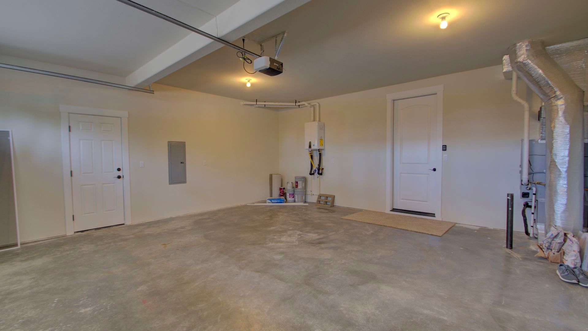 An empty garage with a concrete floor and white walls.
