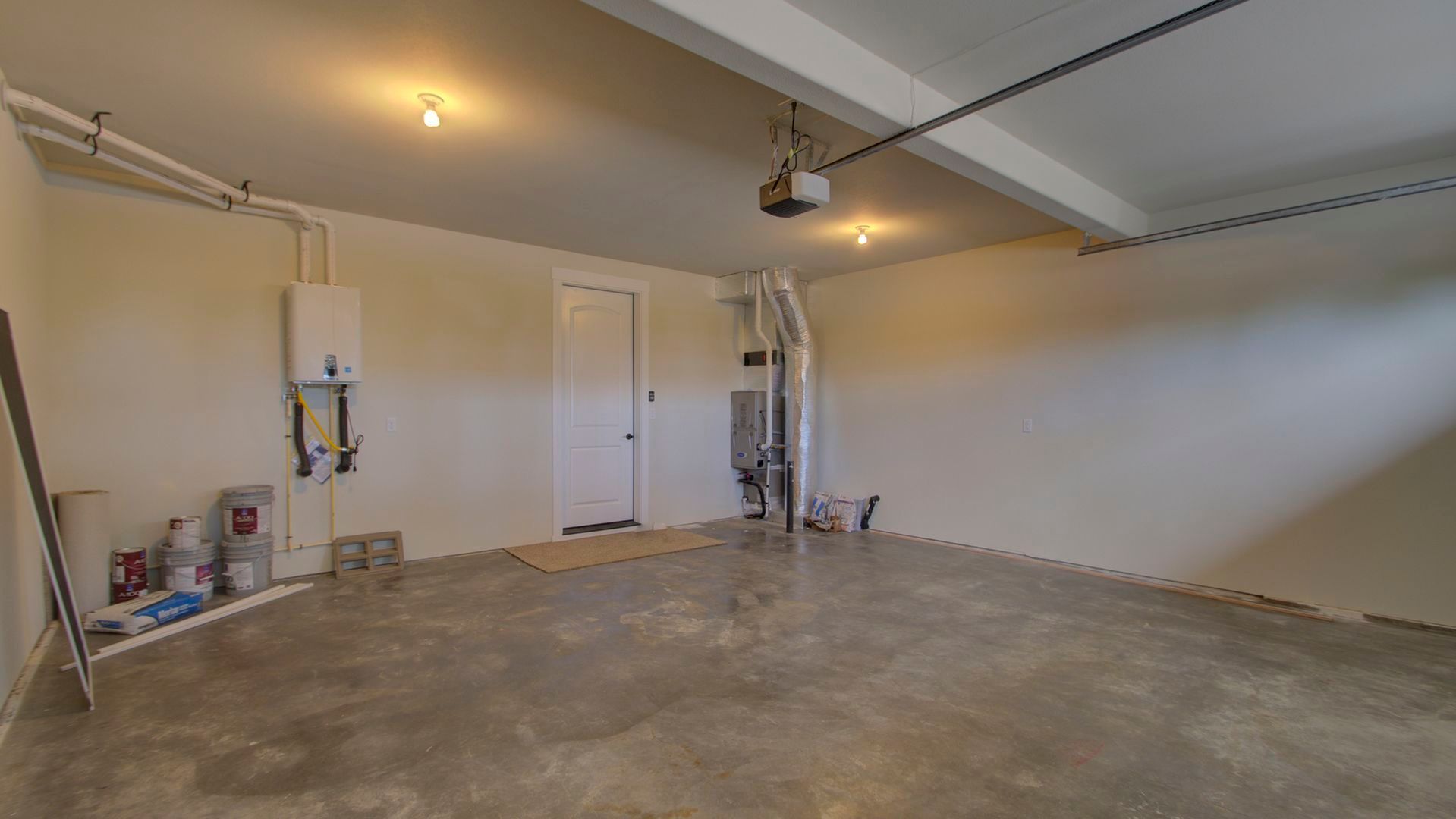 An empty garage with a concrete floor and white walls.