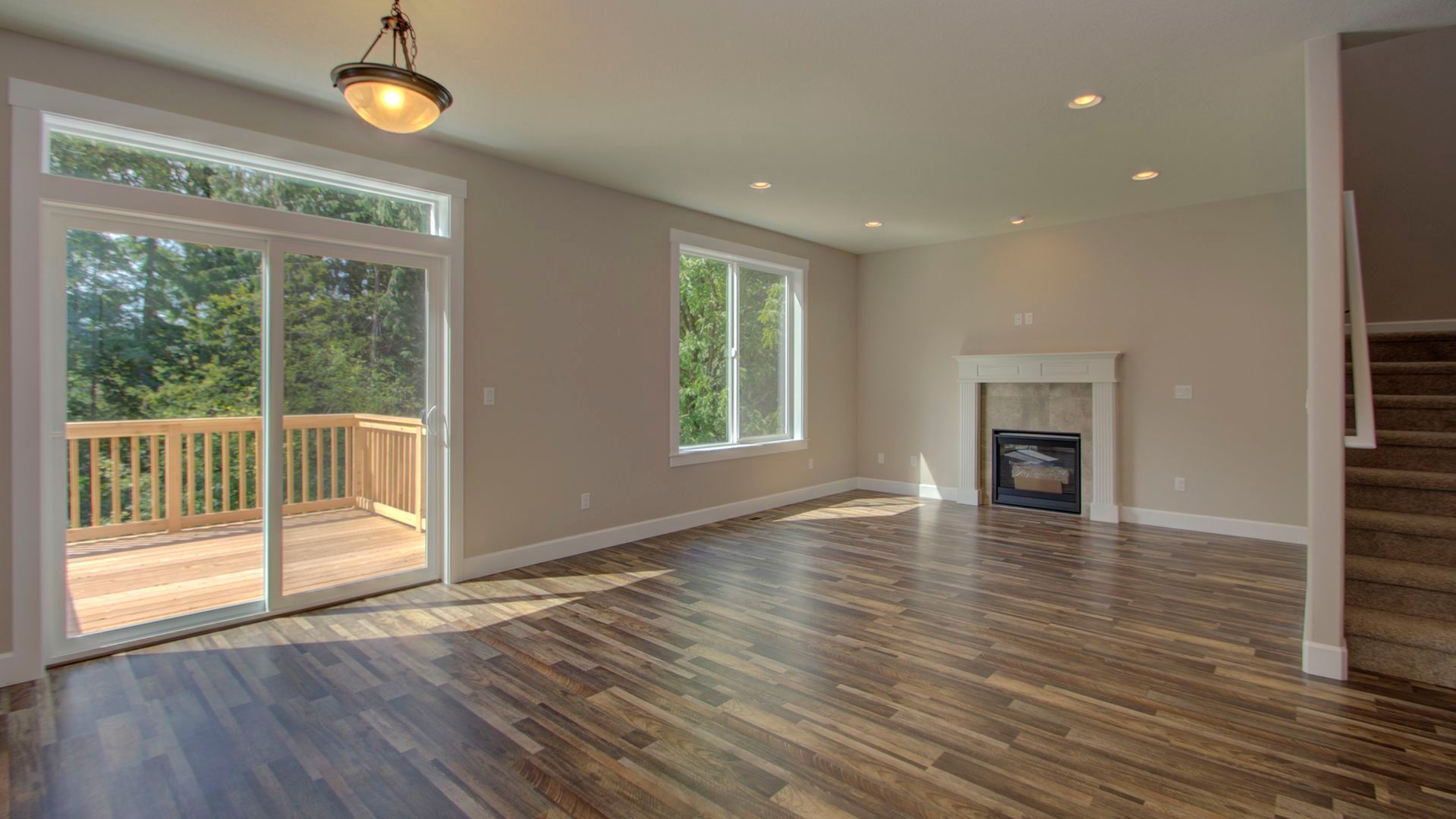 An empty living room with hardwood floors and a fireplace.