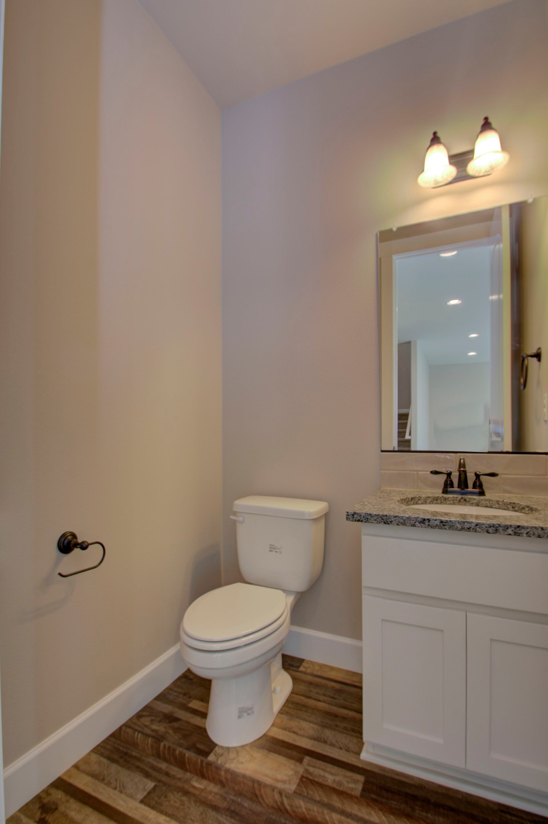 A bathroom with a toilet , sink and mirror