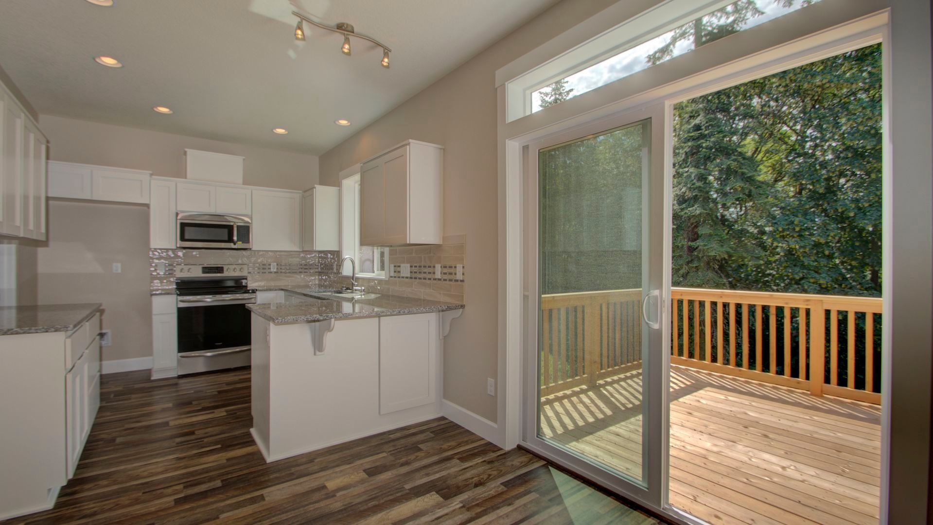 A kitchen with a sliding glass door leading to a deck.