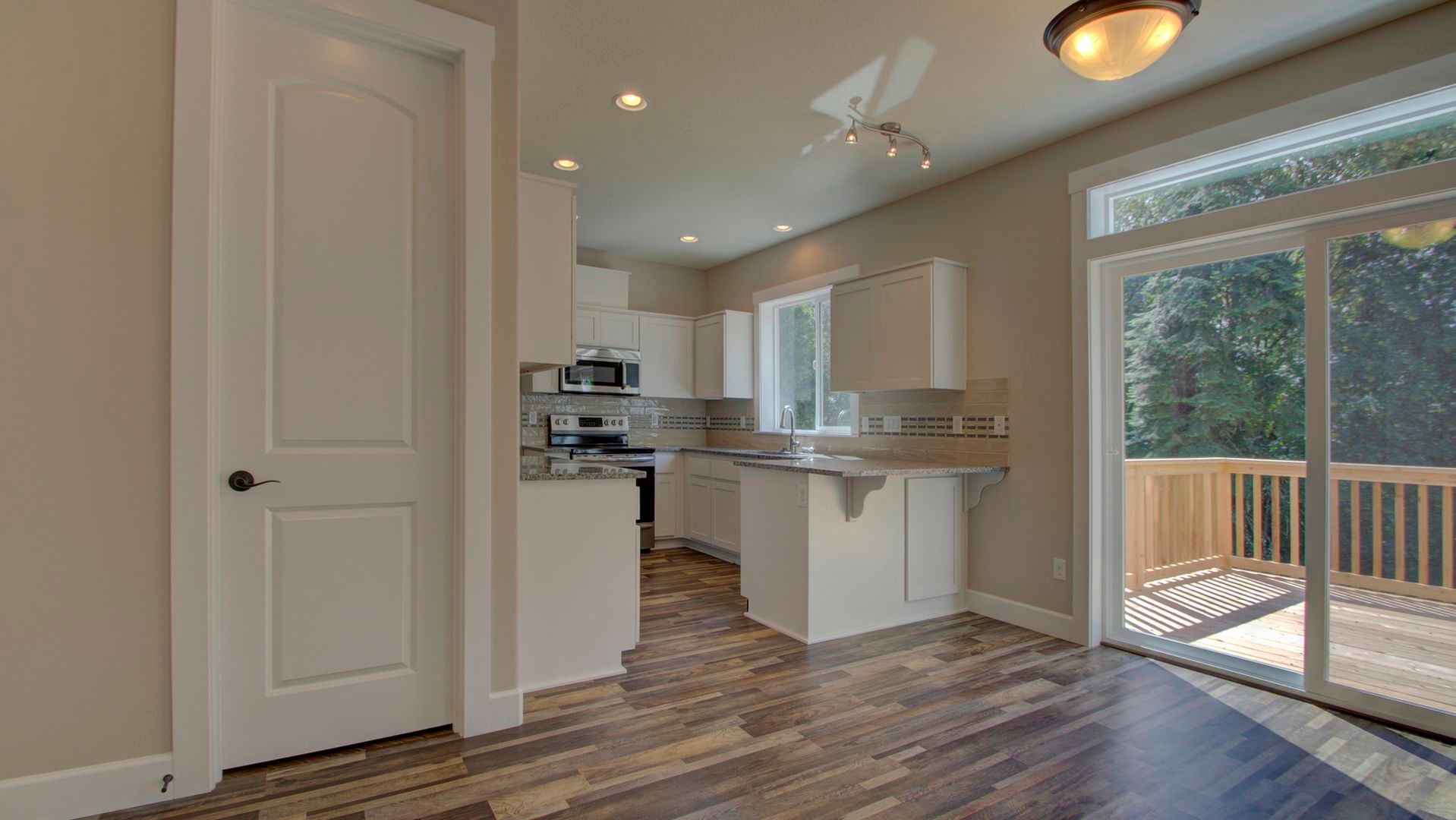 A kitchen with sliding glass doors leading to a deck.