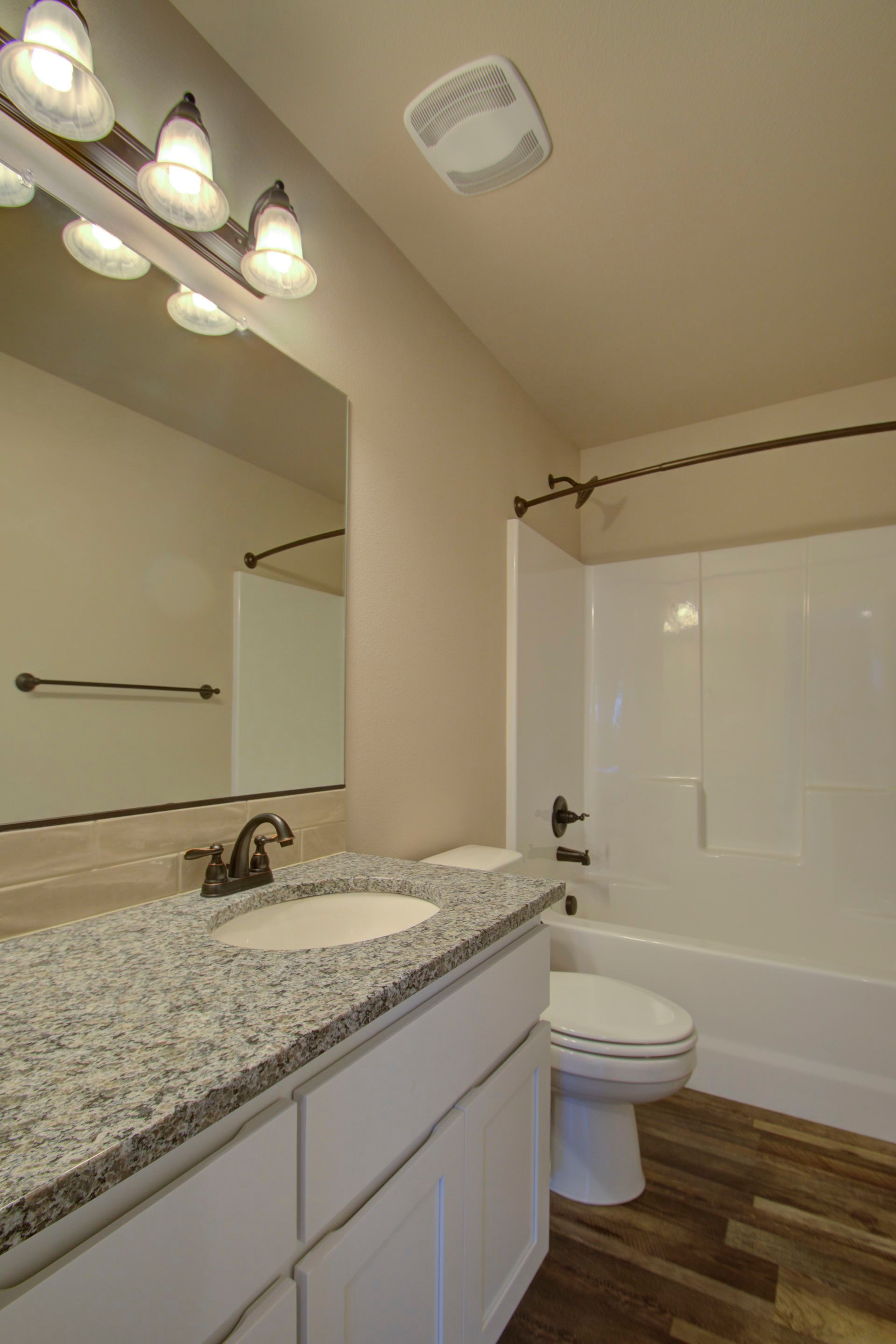 A bathroom with a toilet , sink , and bathtub.