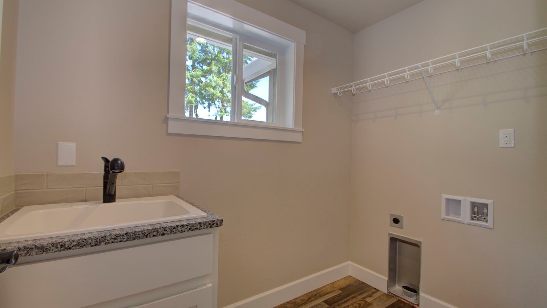 A laundry room with a sink and a window.
