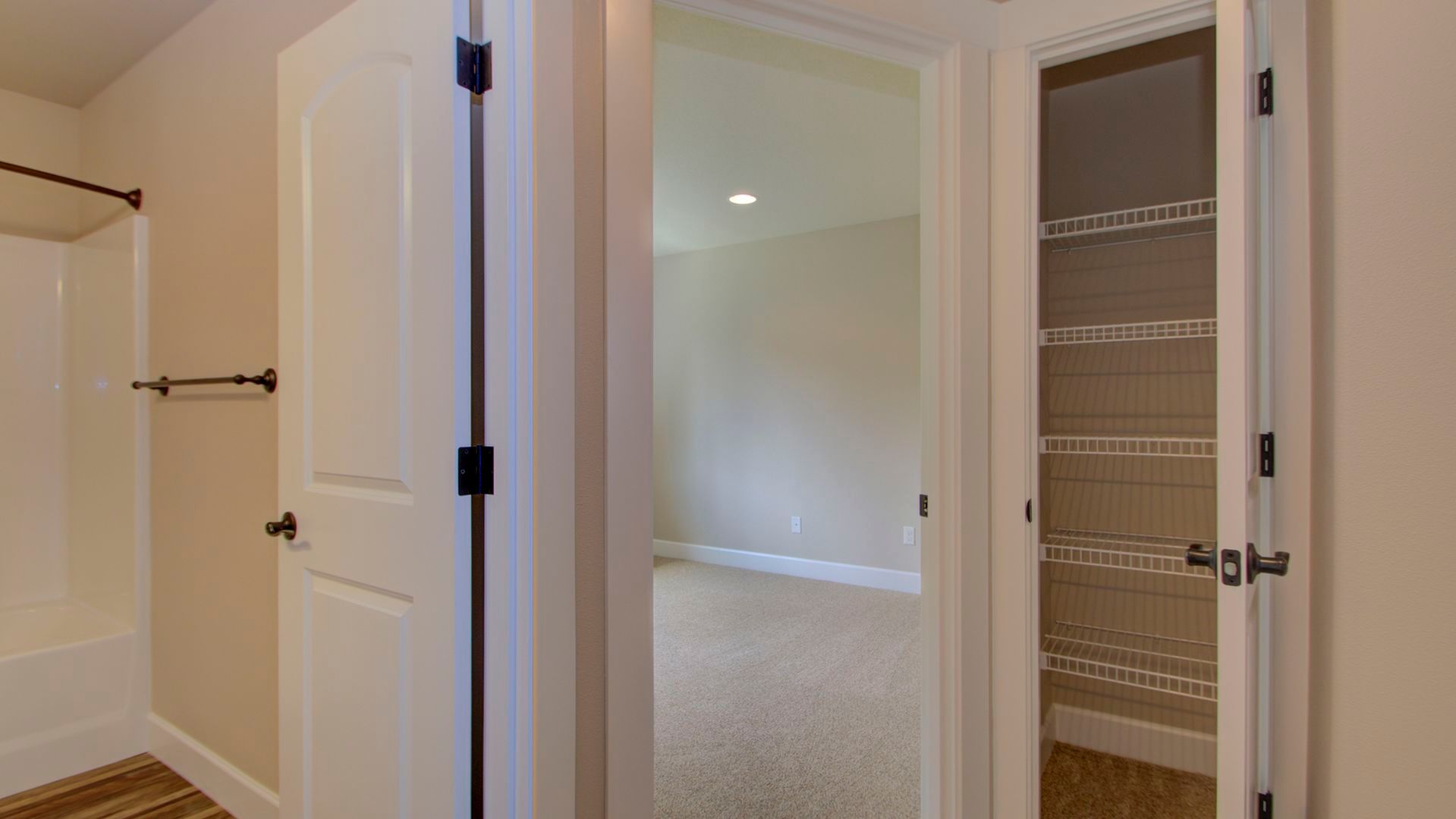 A hallway leading to a bedroom and a closet in a house.