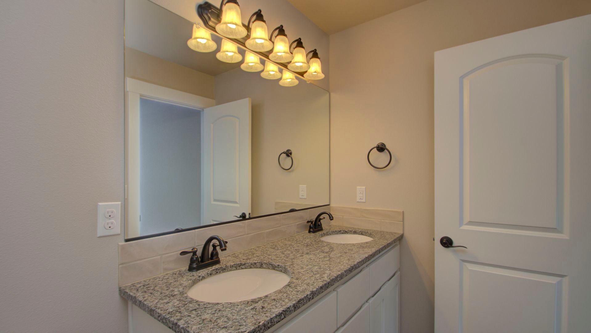 A bathroom with two sinks and a large mirror.