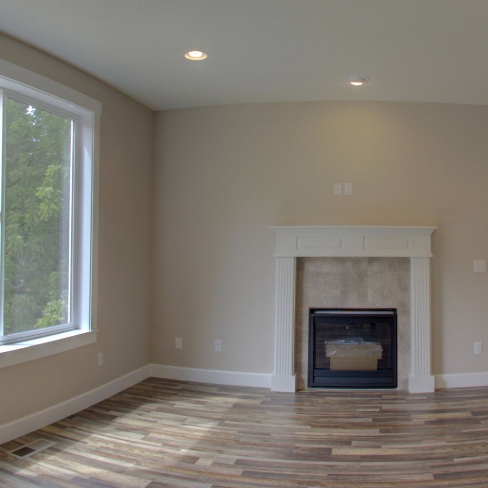 A living room with a fireplace and a large window