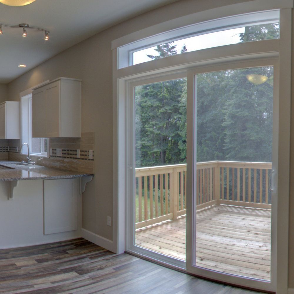 A kitchen with a sliding glass door leading to a deck