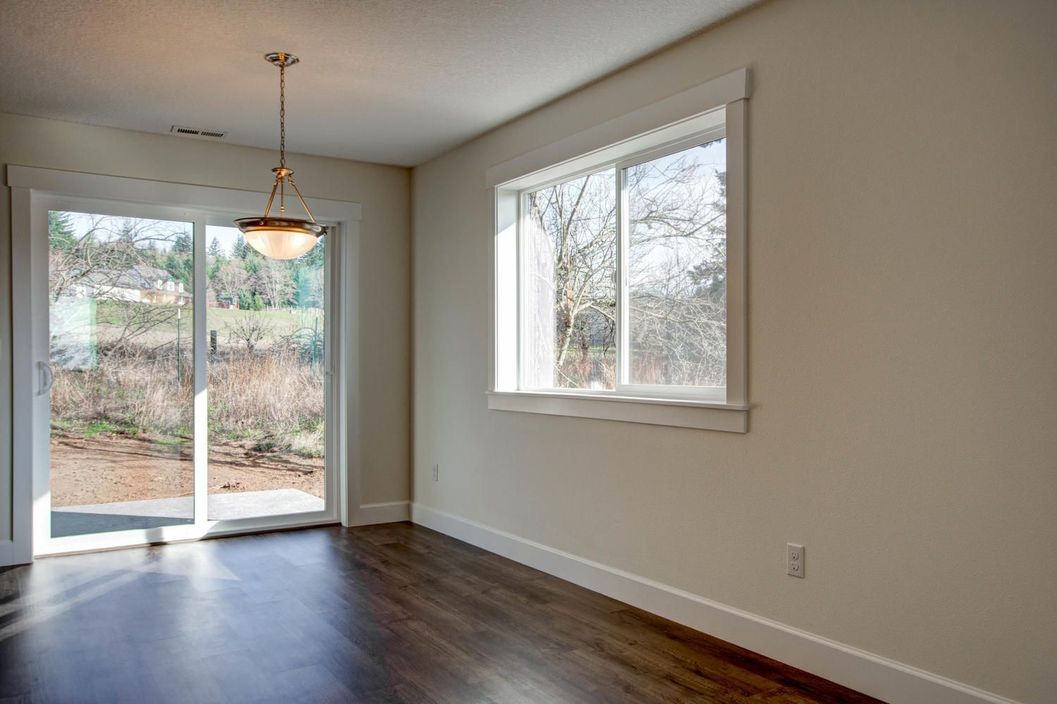 An empty room with a sliding glass door and a window.