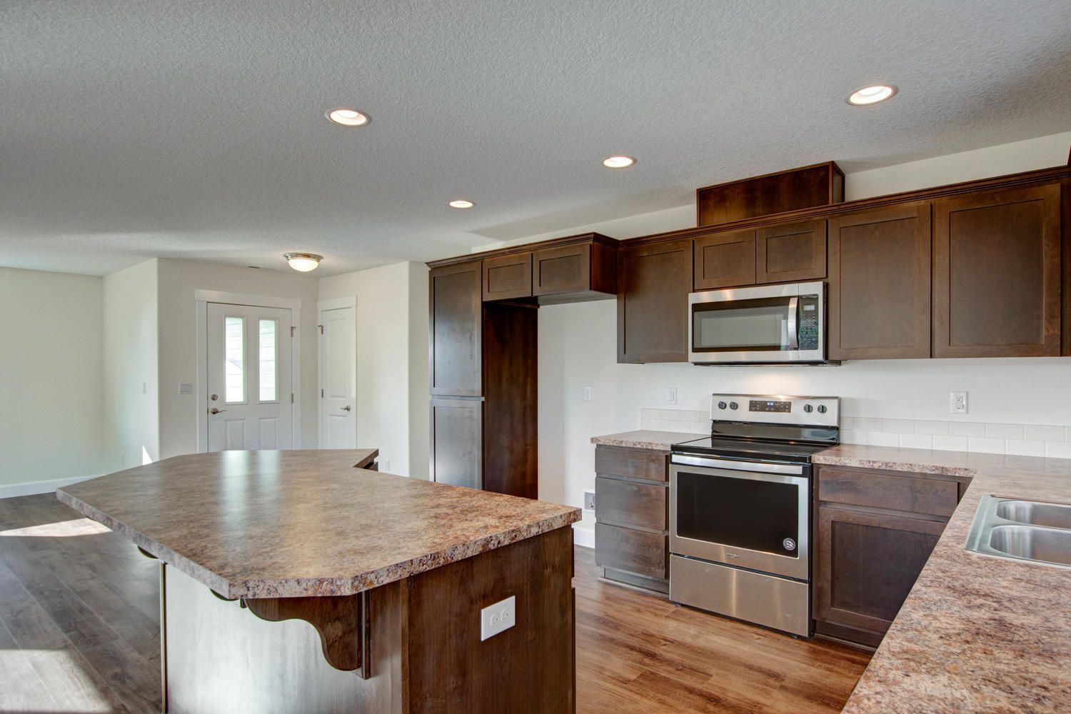 A kitchen with stainless steel appliances and granite counter tops.