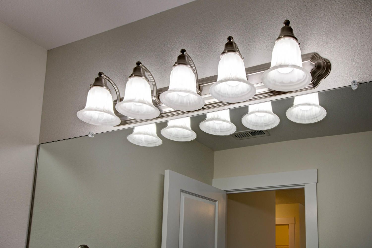 A bathroom with a vanity light and a mirror
