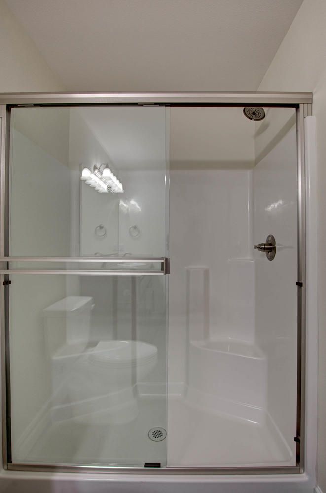 A bathroom with a sliding glass shower door and a bathtub.