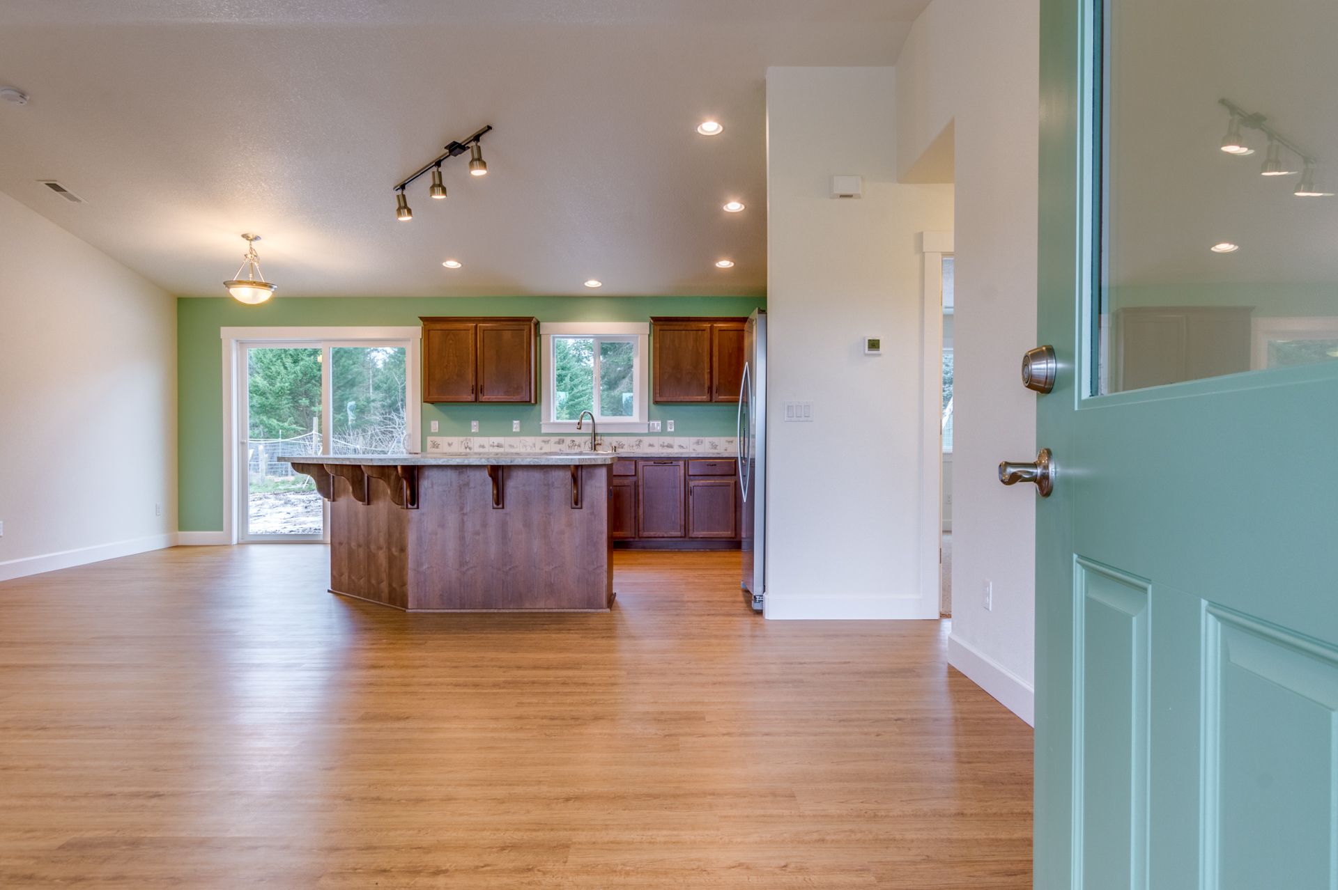 The door is open to a kitchen with hardwood floors.