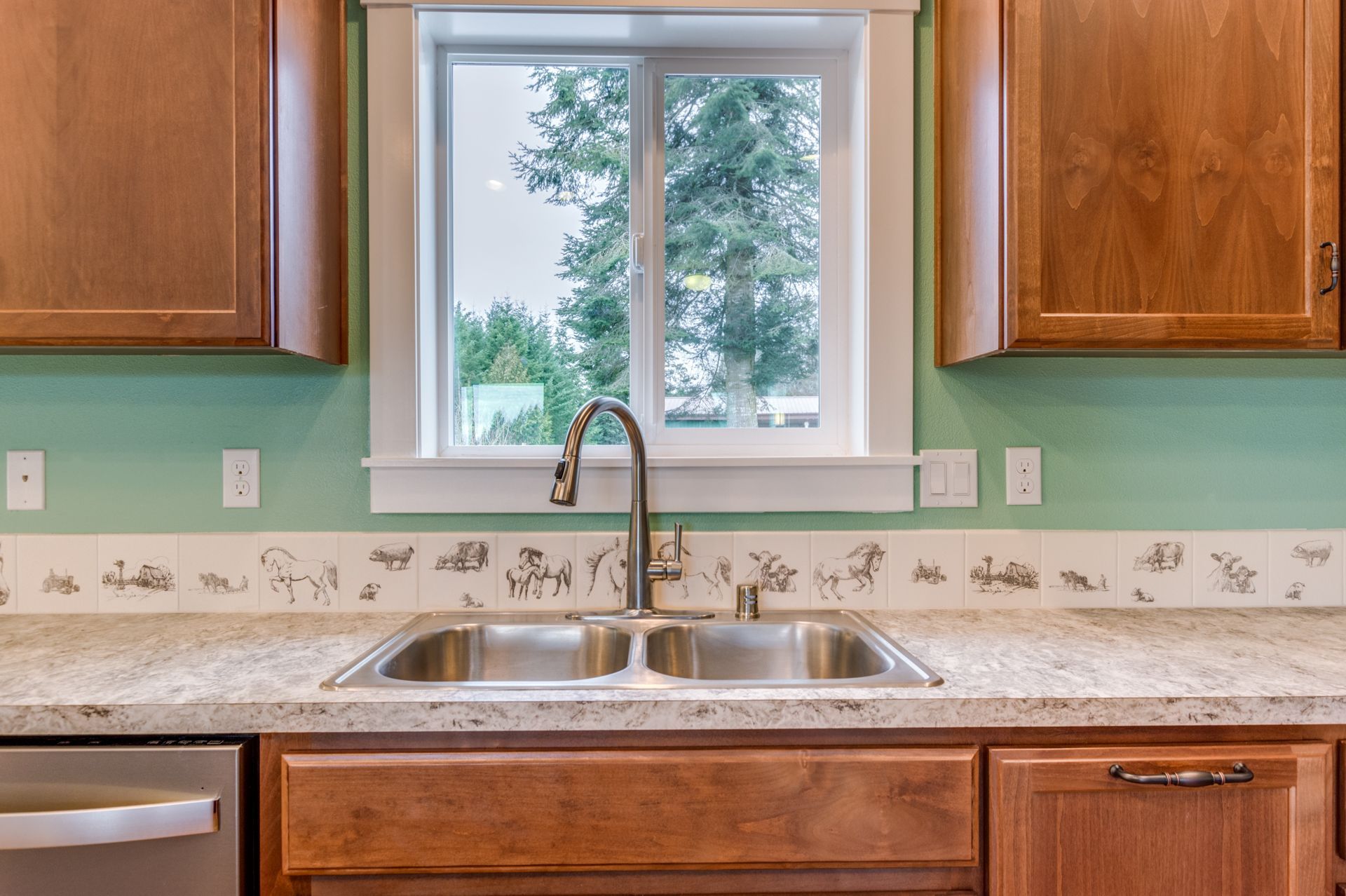 A kitchen with a sink , dishwasher , and window.