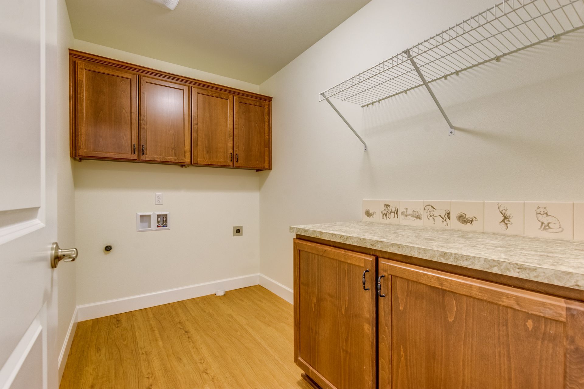 A laundry room with wooden cabinets and a counter top.
