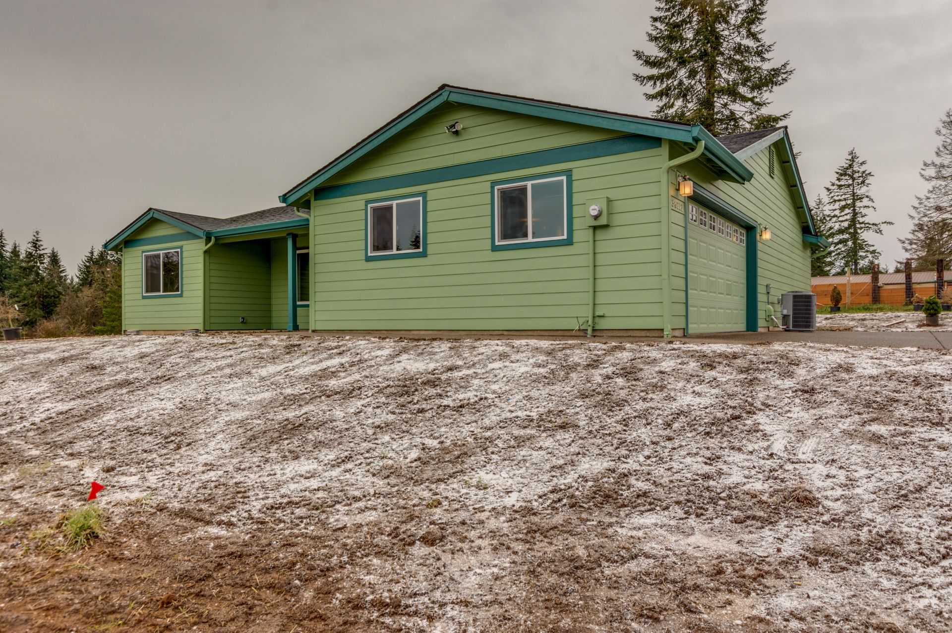 A green house sits on top of a snowy hill