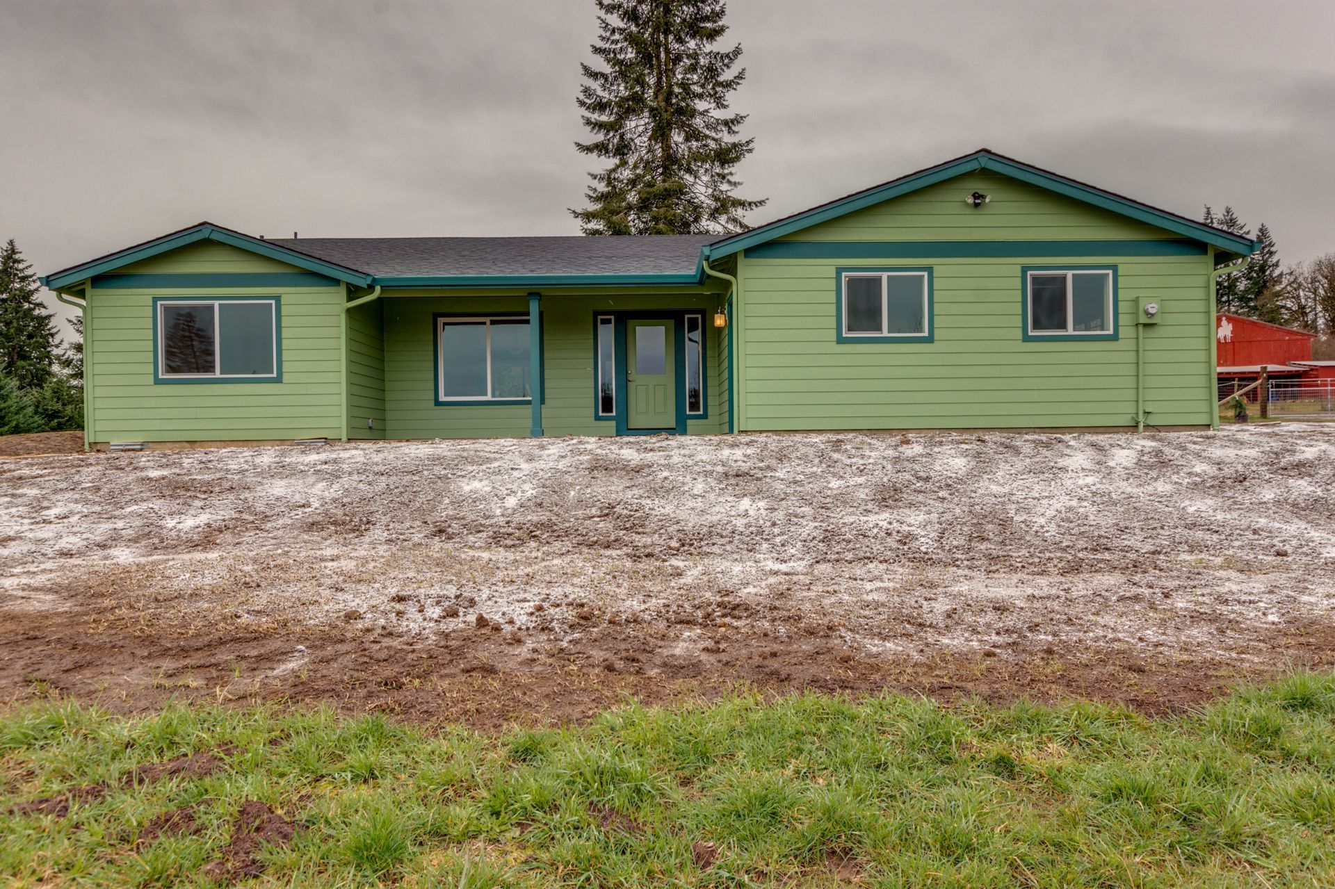 A green house sits in the middle of a grassy field