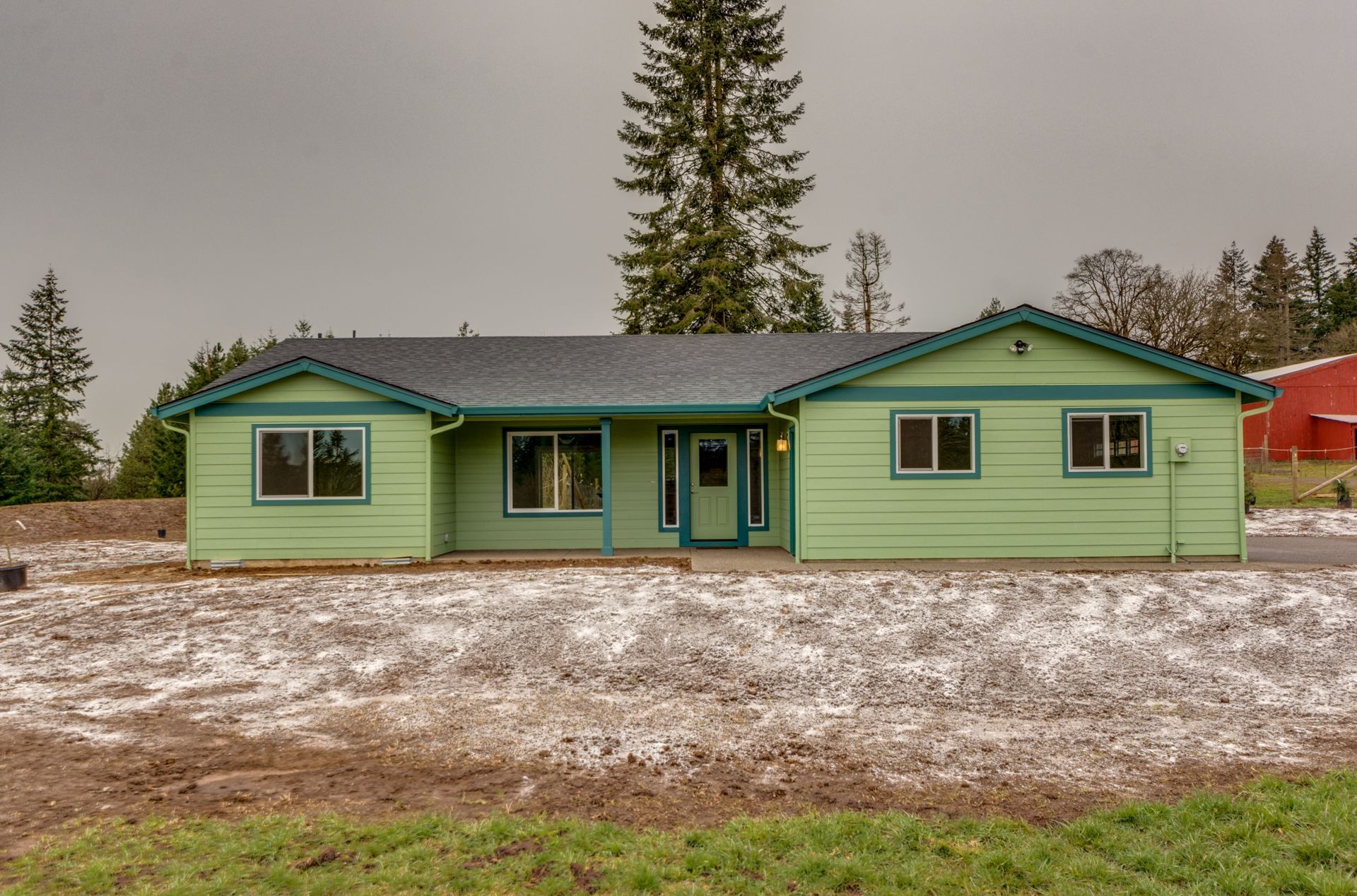 A green house is sitting in the middle of a grassy field.