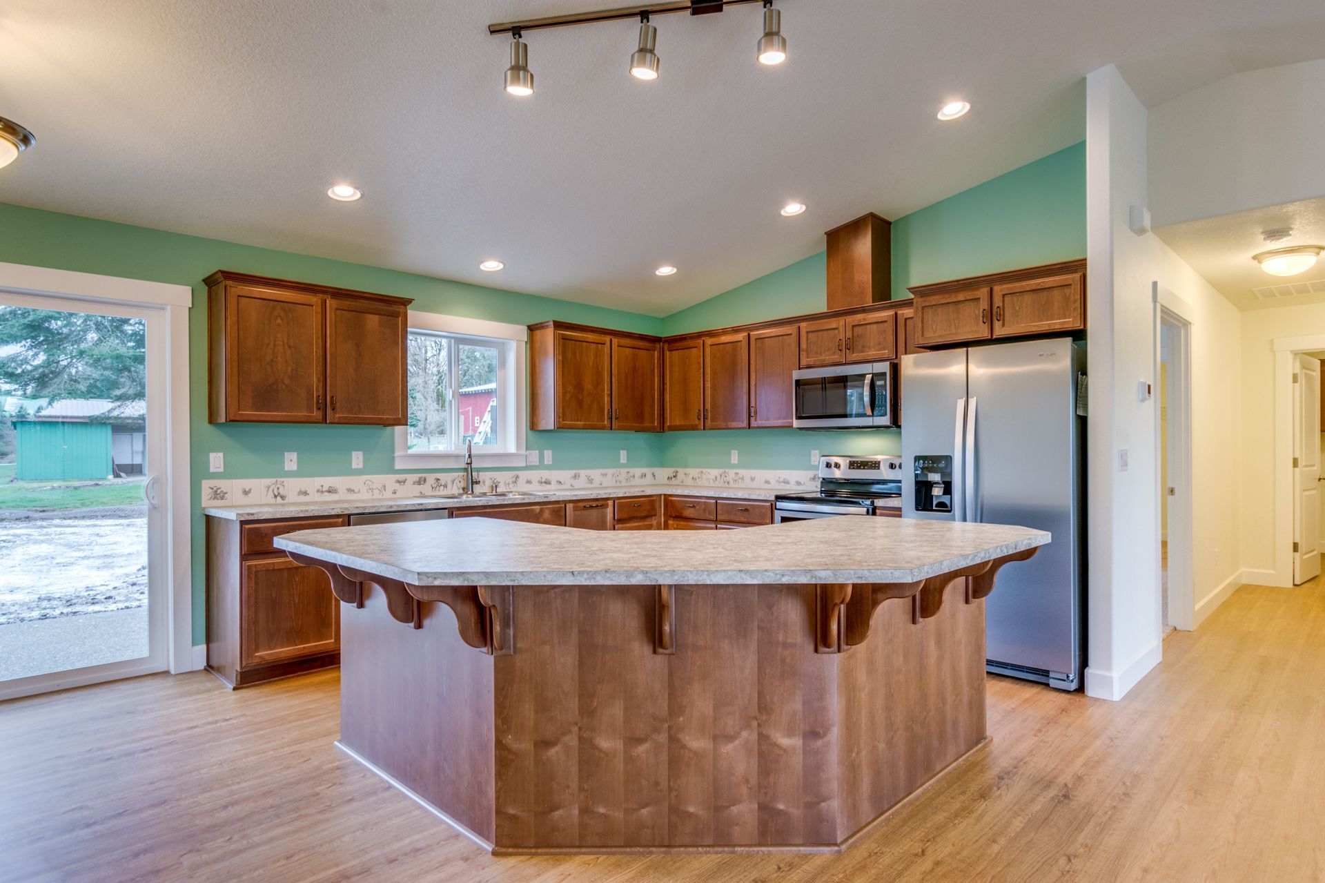 A kitchen with a large island and stainless steel appliances