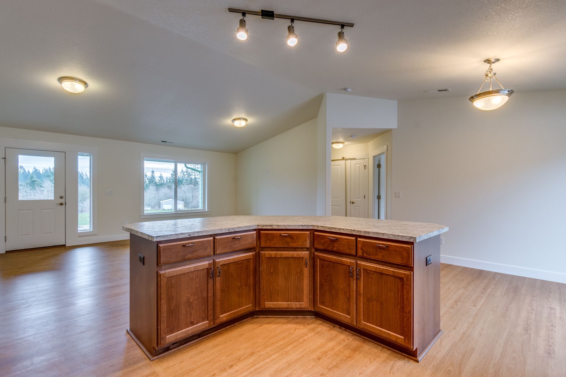 An empty kitchen with wooden cabinets and a large island.