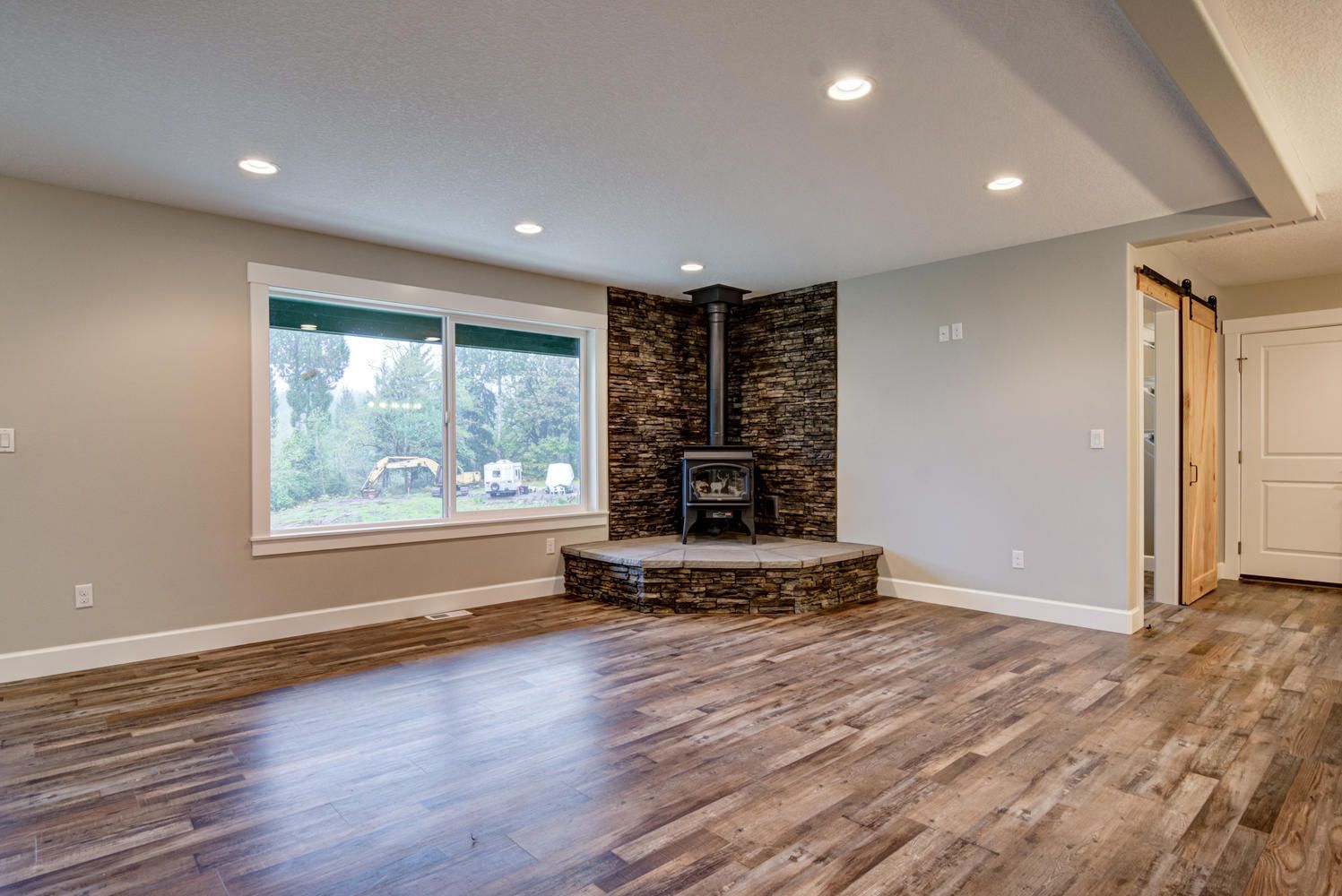 An empty living room with hardwood floors and a fireplace.