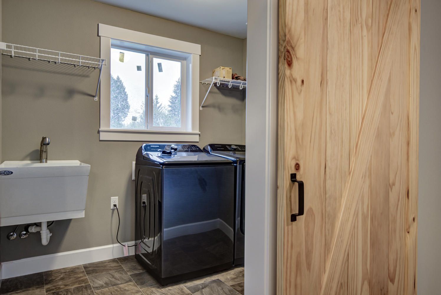 A laundry room with a washer and dryer and a sink.