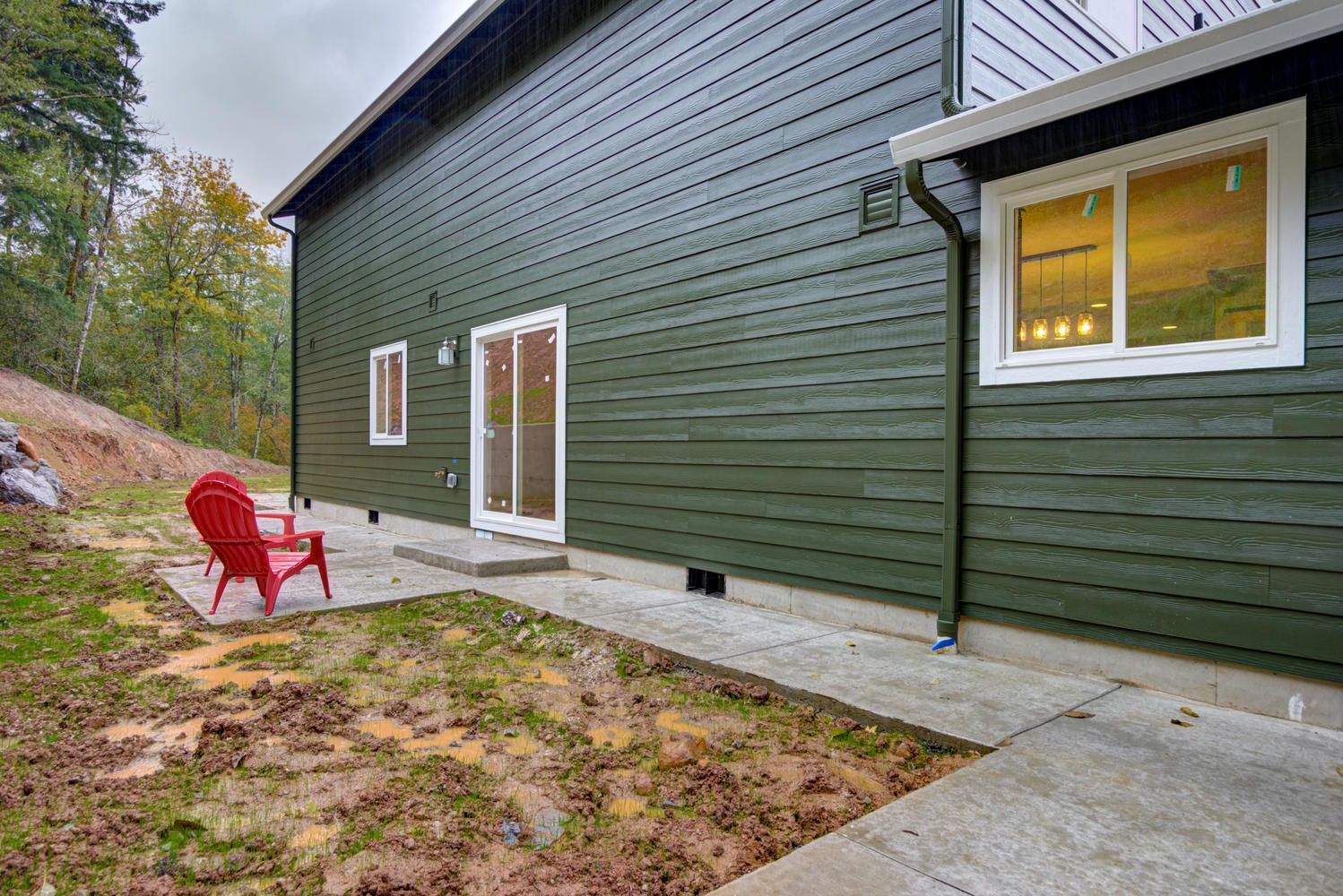 A green house with a red chair in front of it.
