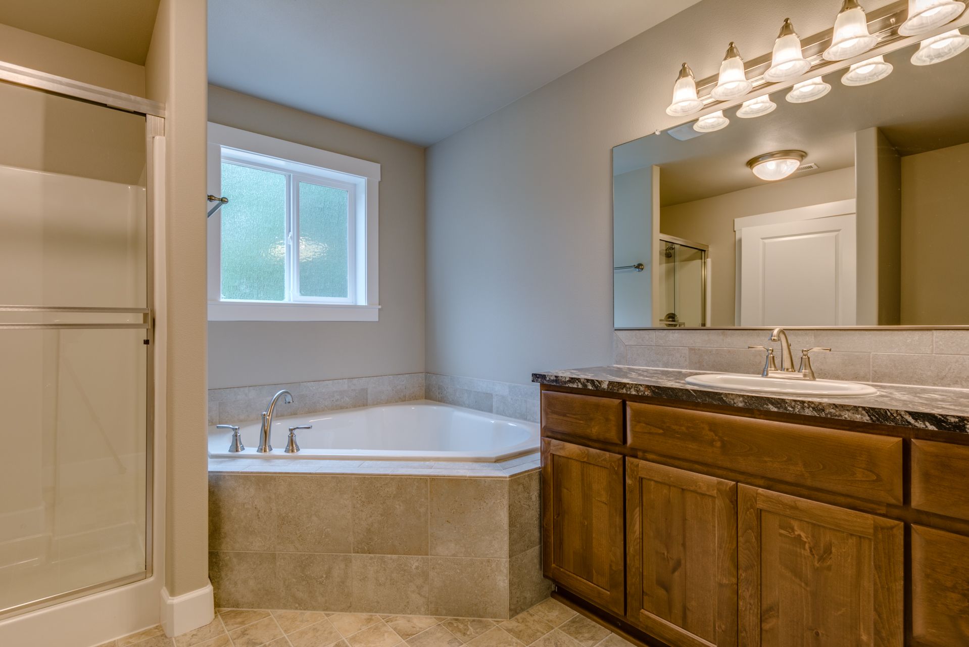 A bathroom with a tub , sink , and mirror.
