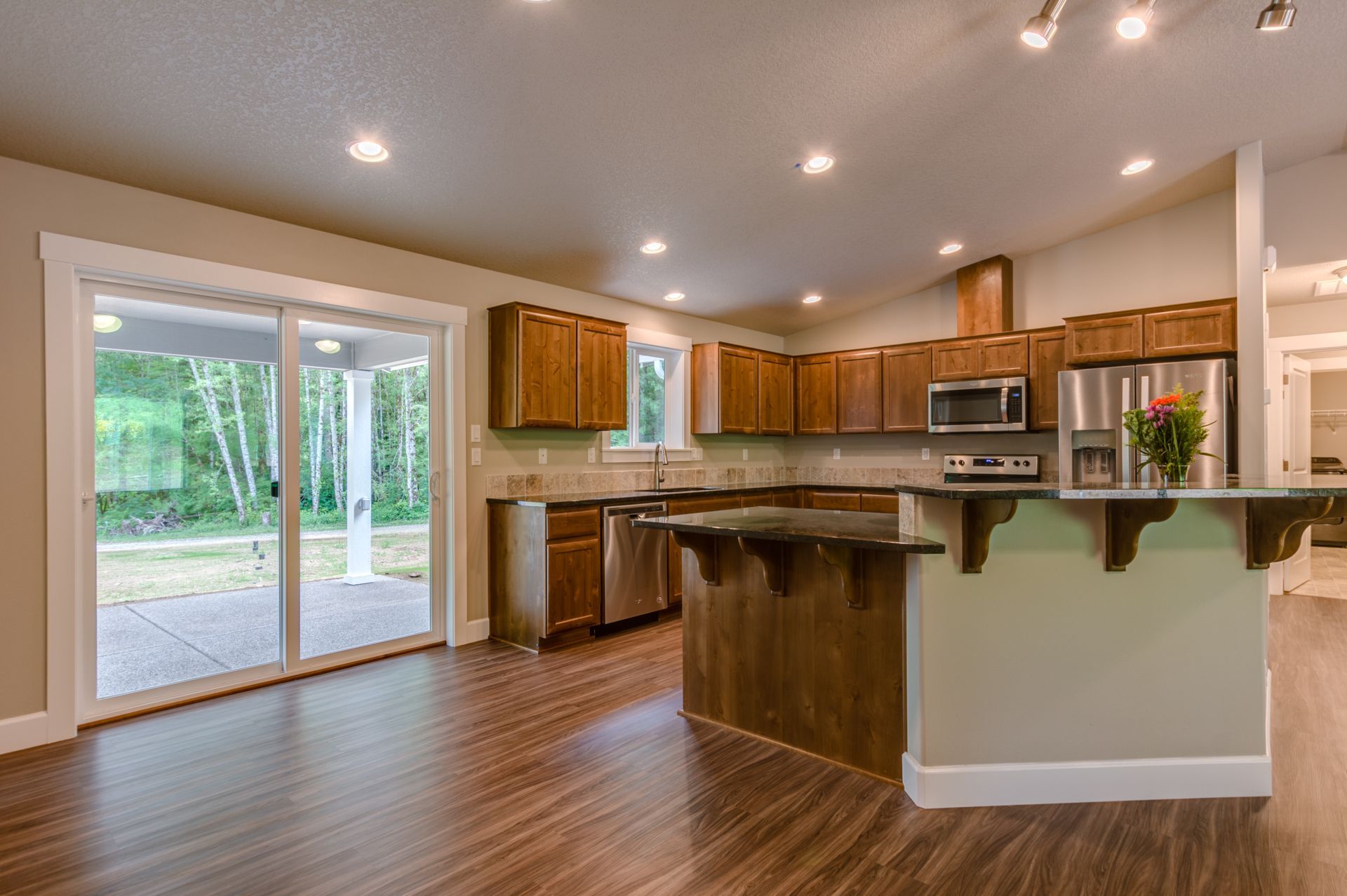 A kitchen with wooden cabinets , stainless steel appliances , and a large island.