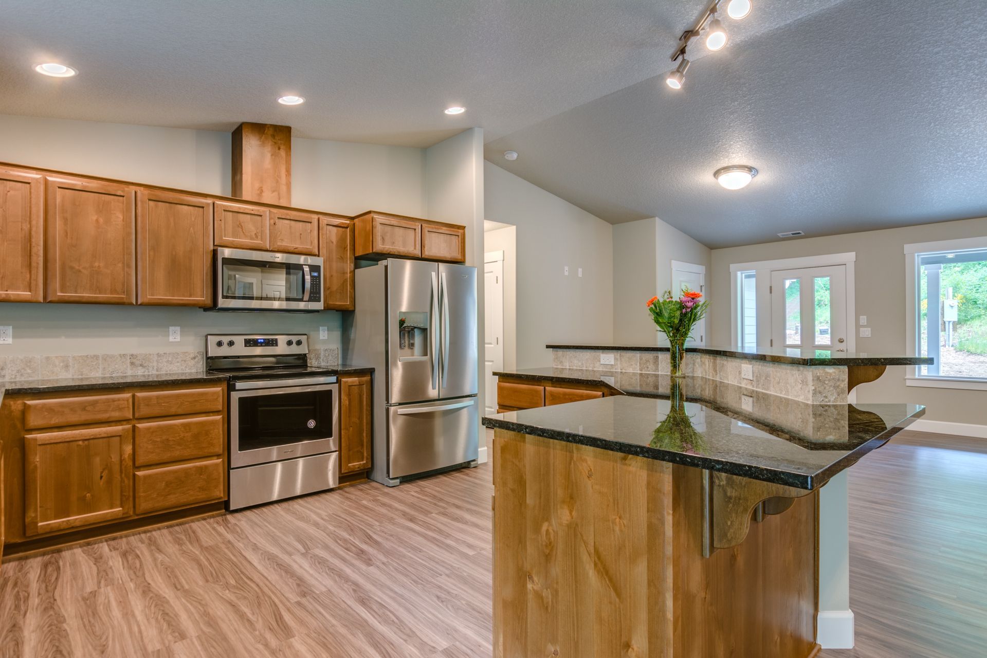 A kitchen with stainless steel appliances and wooden cabinets.