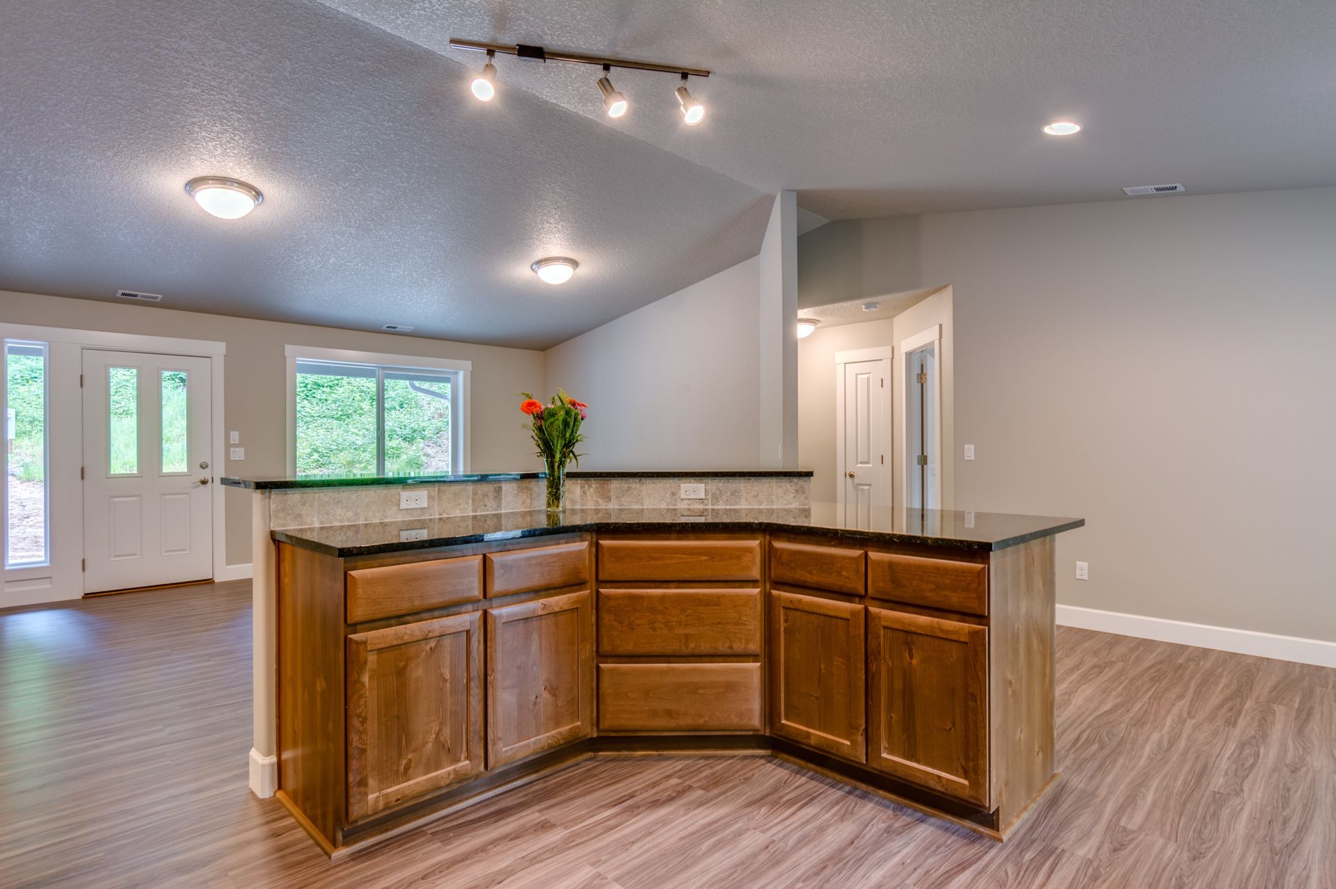 A kitchen with wooden cabinets and a large island in the middle of the room.