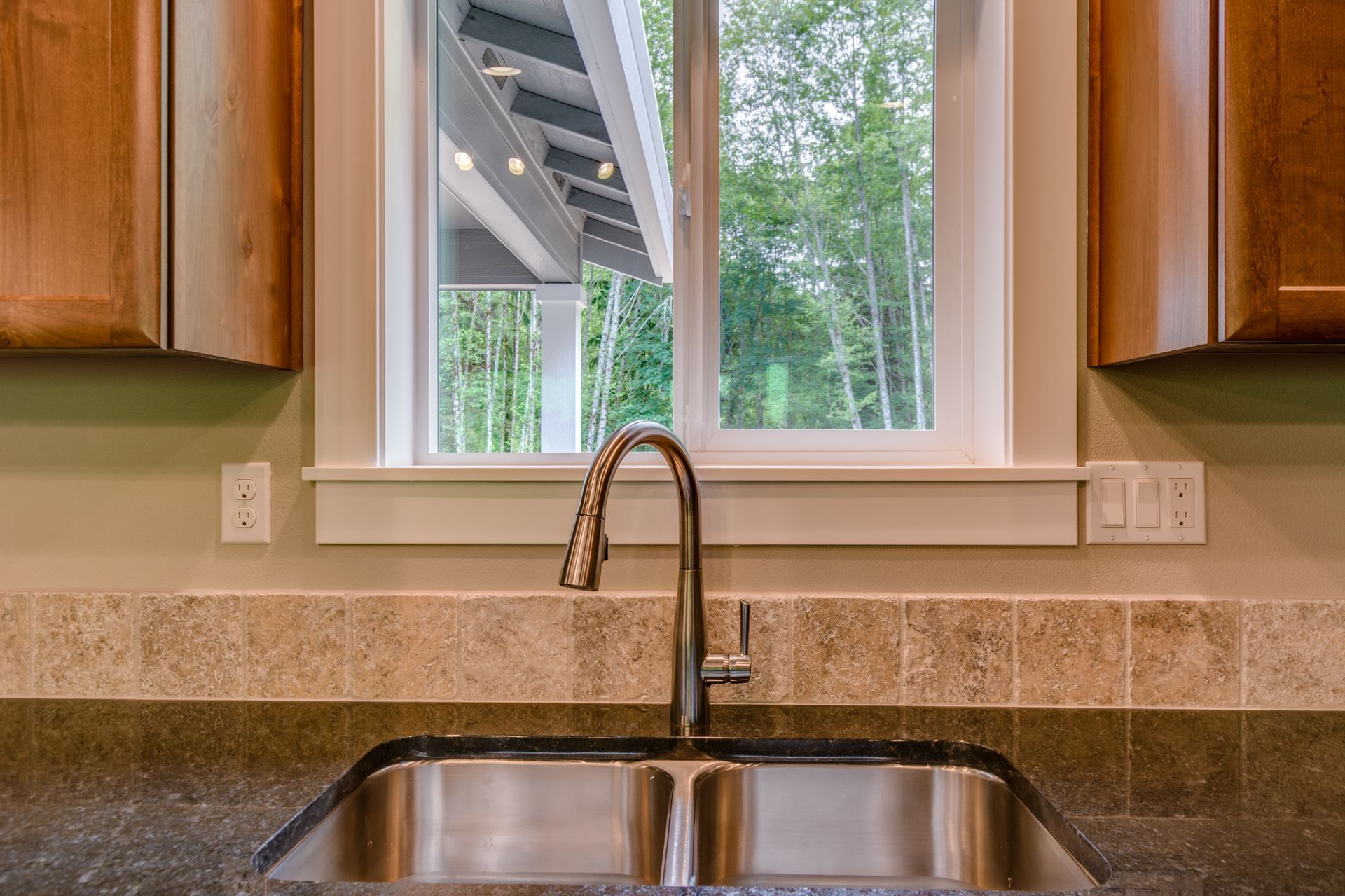 A kitchen sink with a window above it and a faucet.