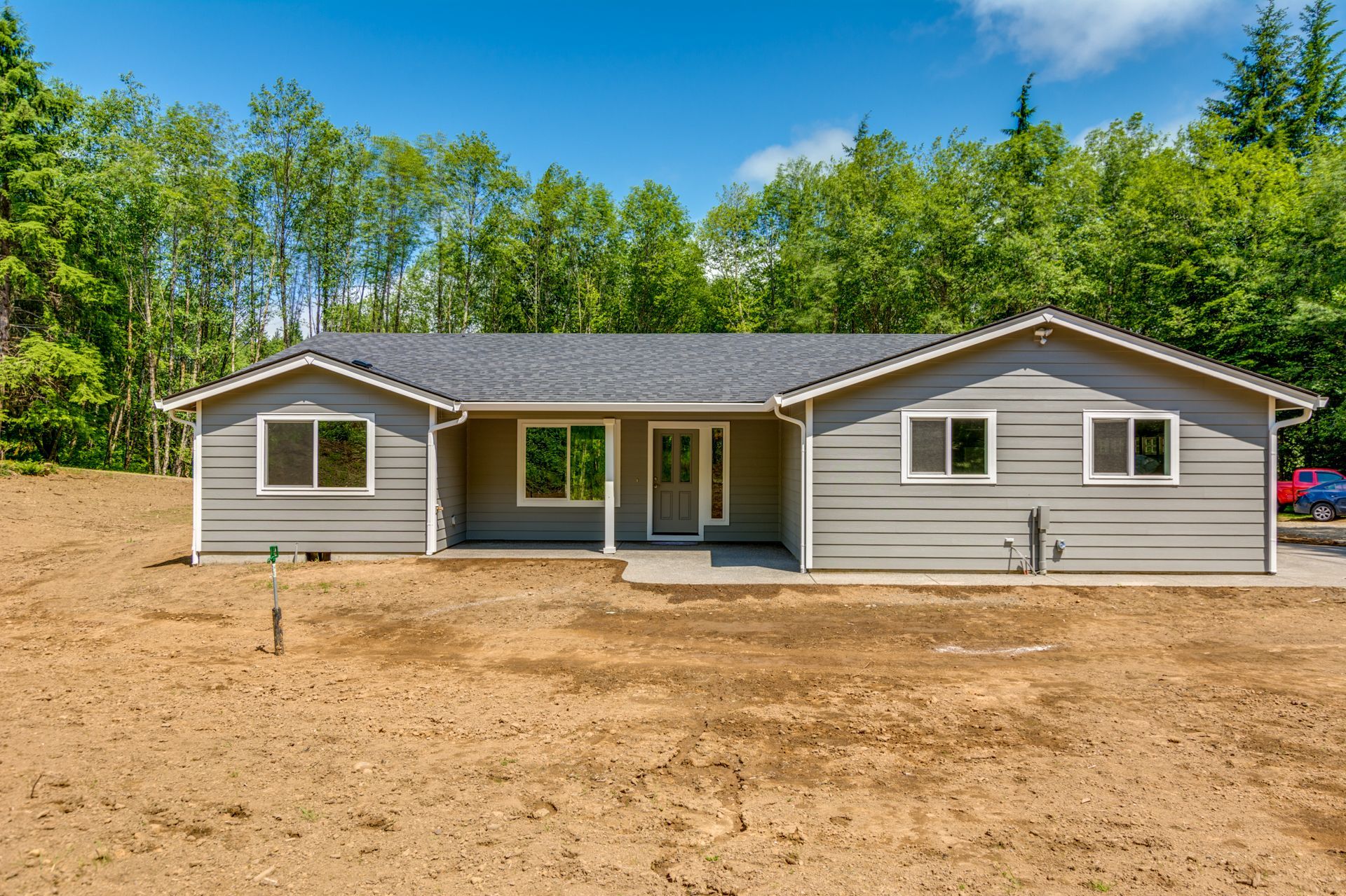 A house is sitting in the middle of a dirt field