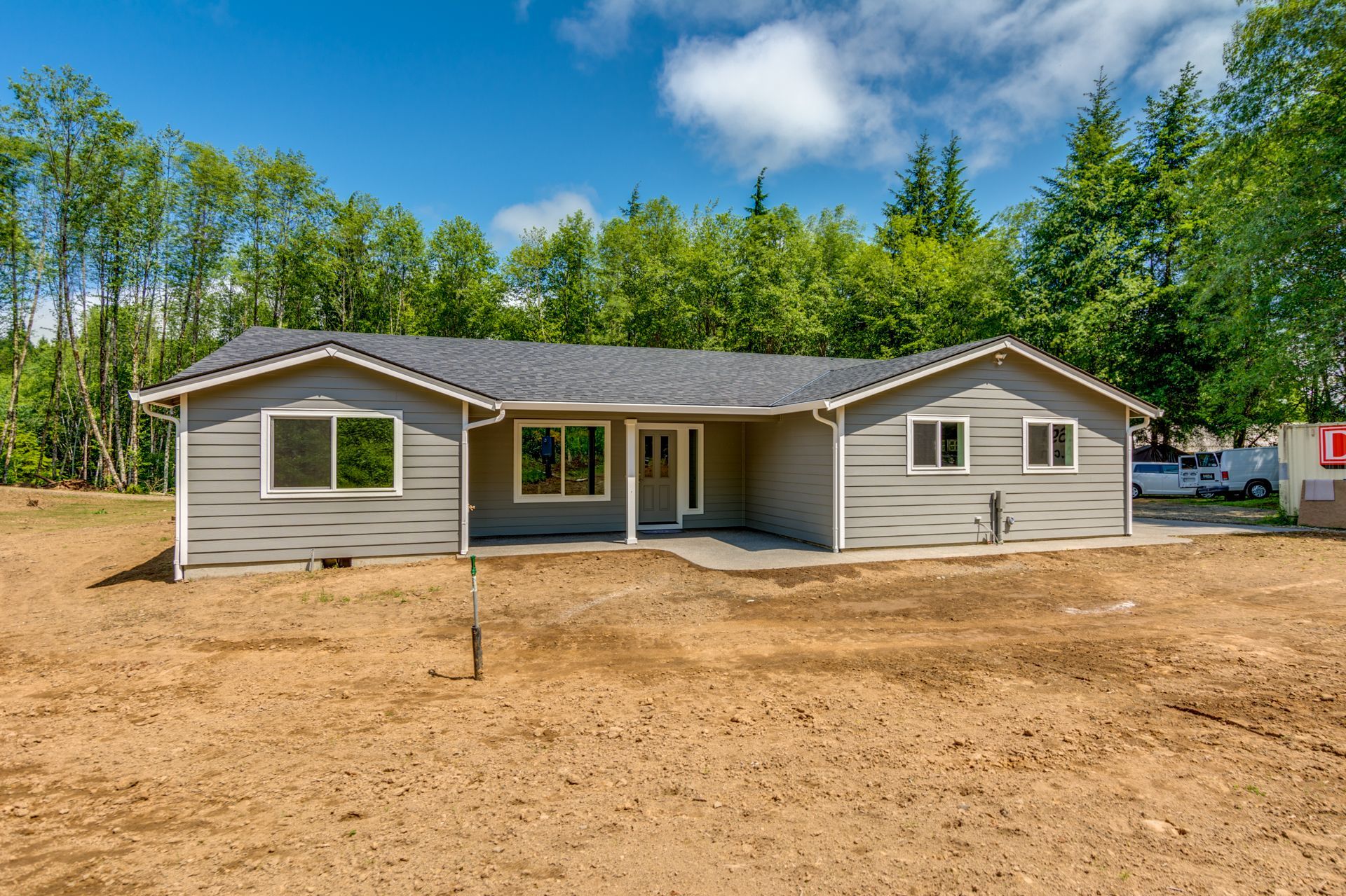 A house is sitting in the middle of a dirt field