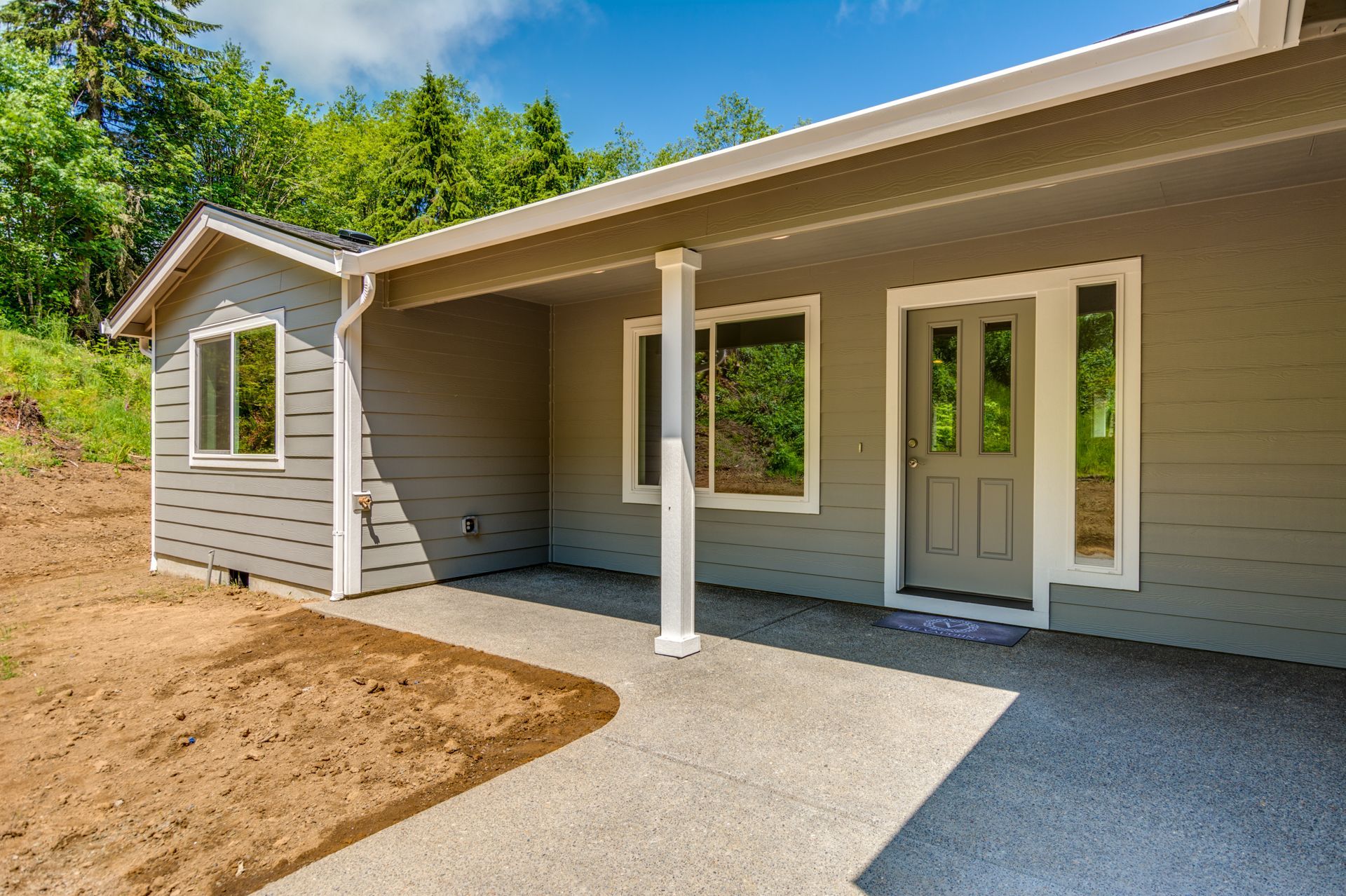 A house with a porch and a driveway in front of it.