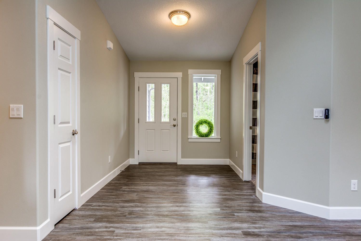 A hallway in a house with a wreath in the window.