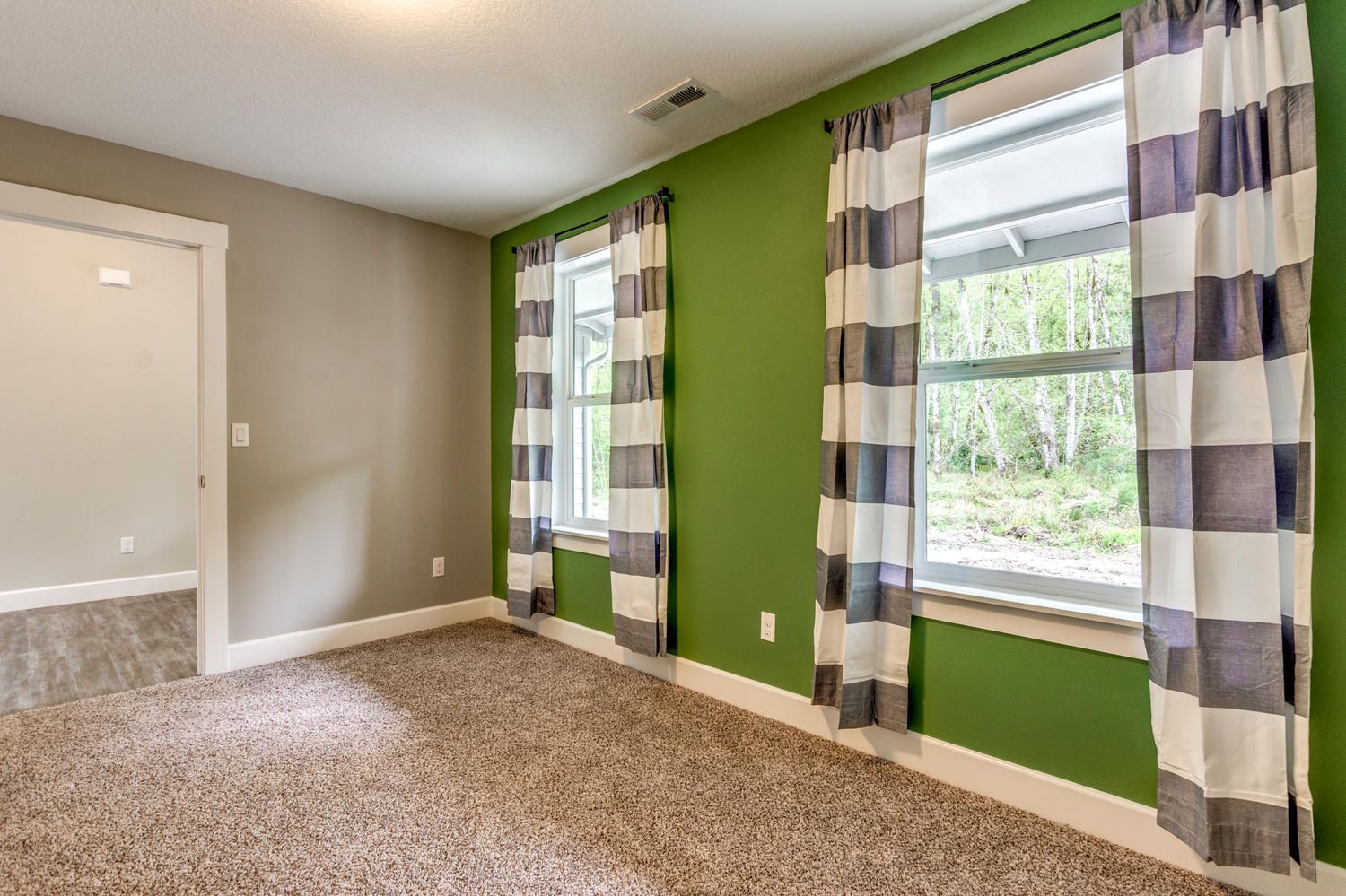 An empty room with green walls and a carpeted floor.