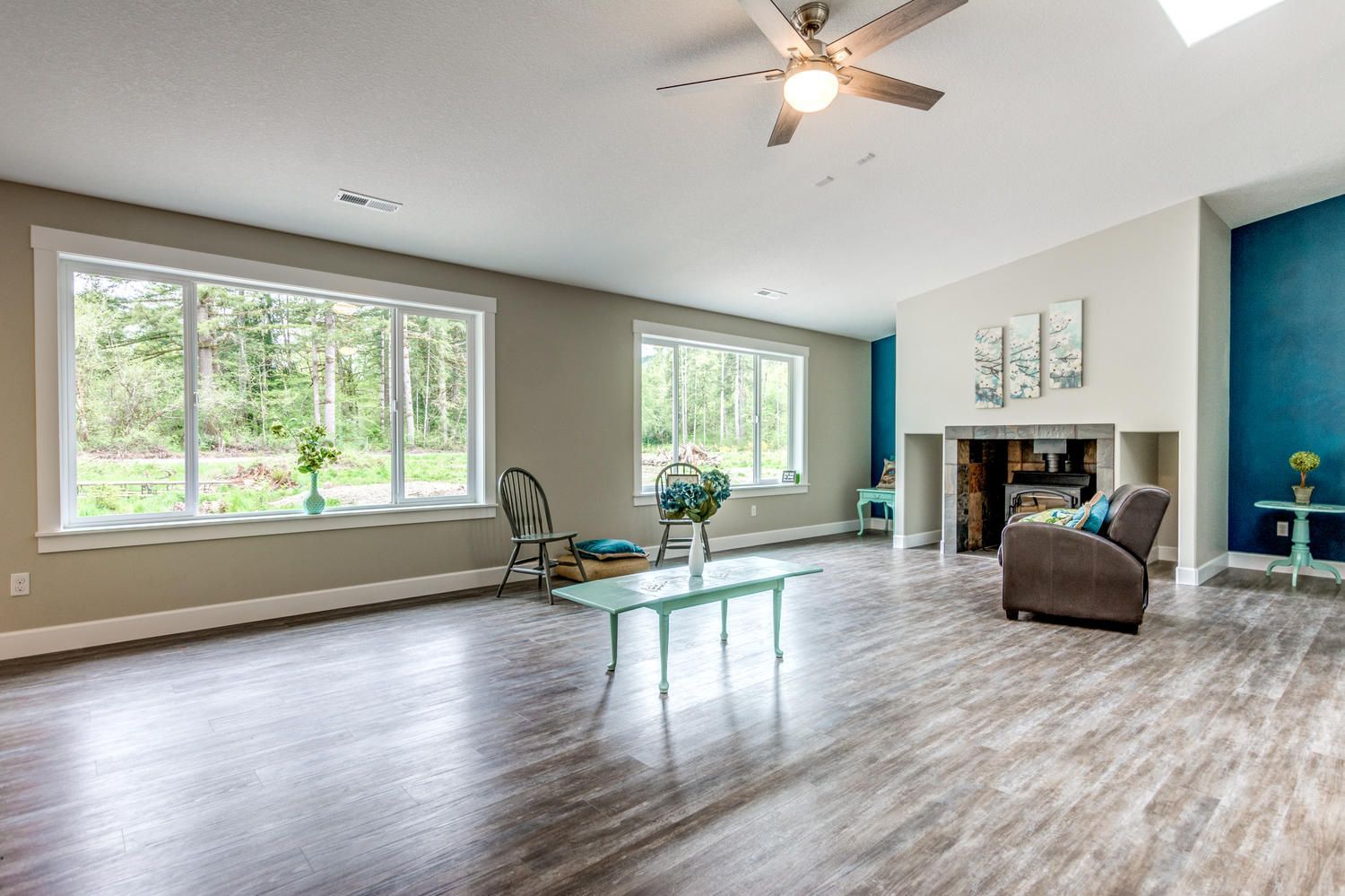 A living room with a ceiling fan and a fireplace.