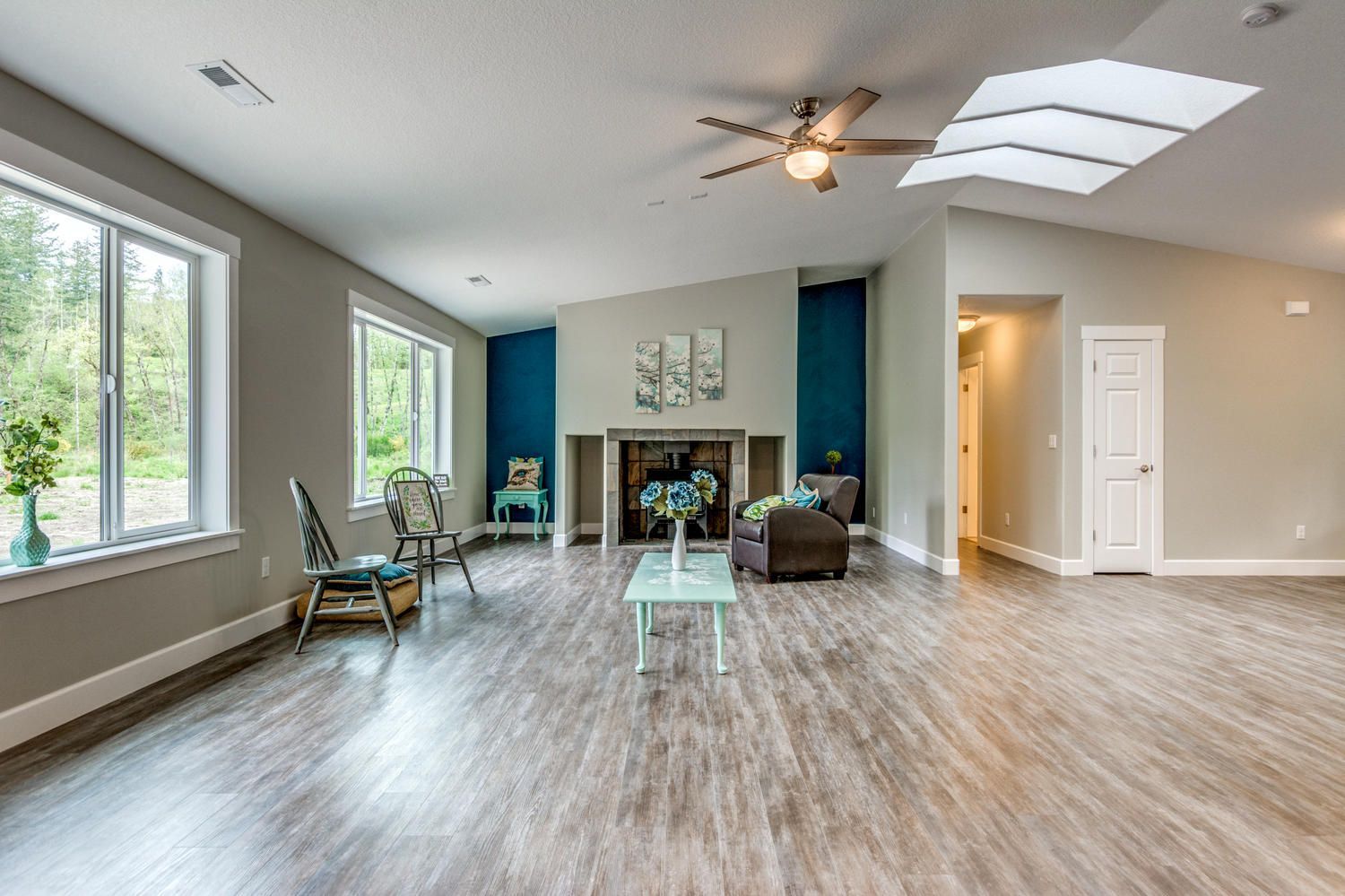 A living room with hardwood floors and a ceiling fan.