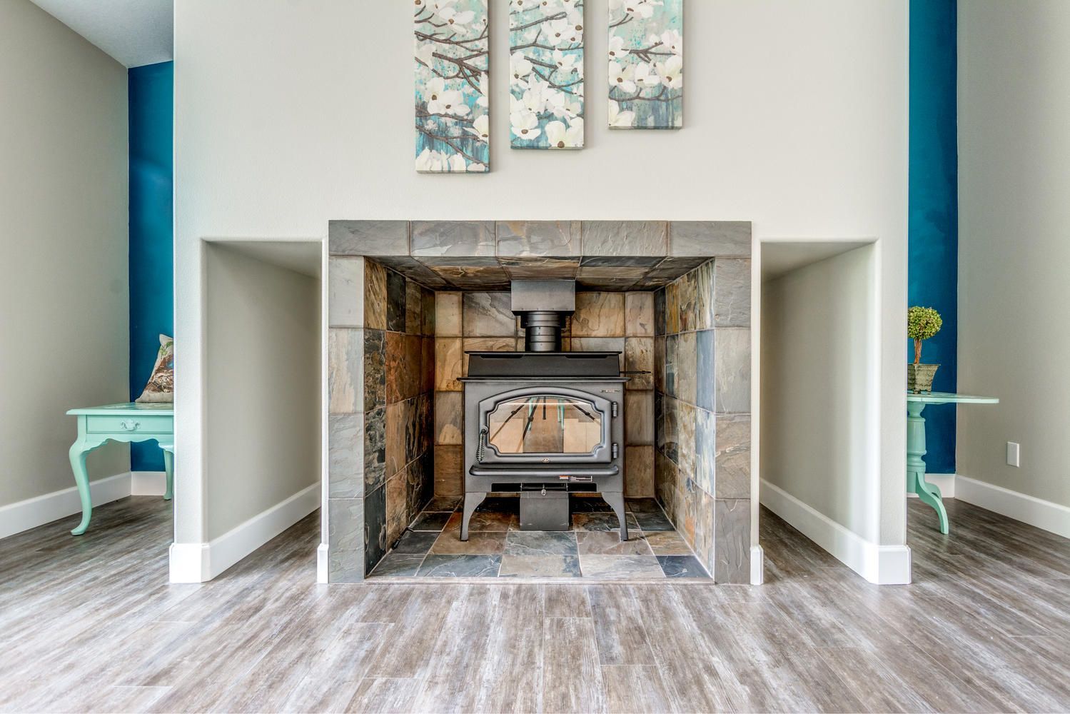 A wood stove is sitting in a fireplace in a living room.
