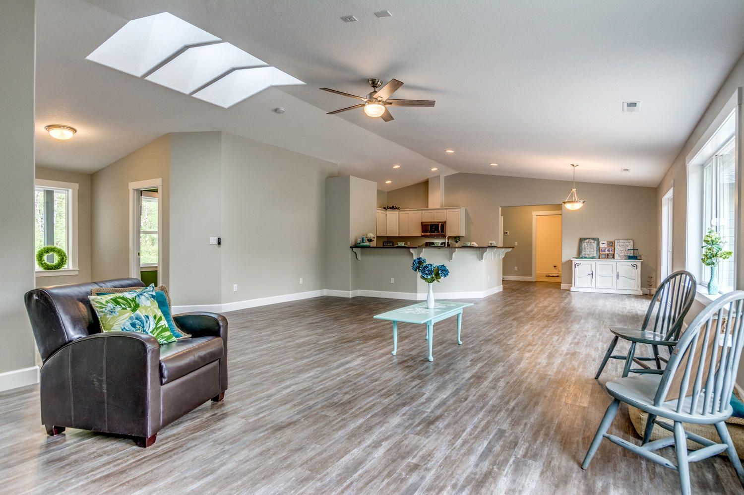 A living room with hardwood floors and a ceiling fan.