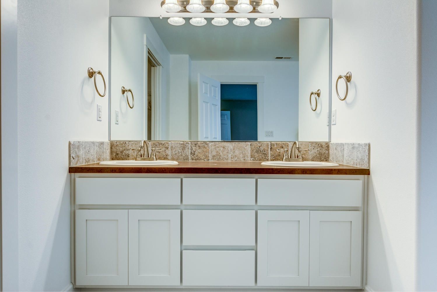A bathroom with two sinks and a large mirror