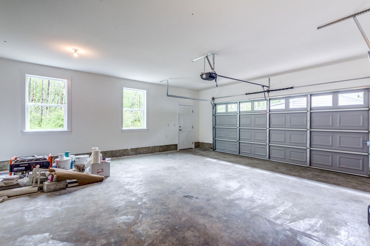 A large empty garage with a garage door open.