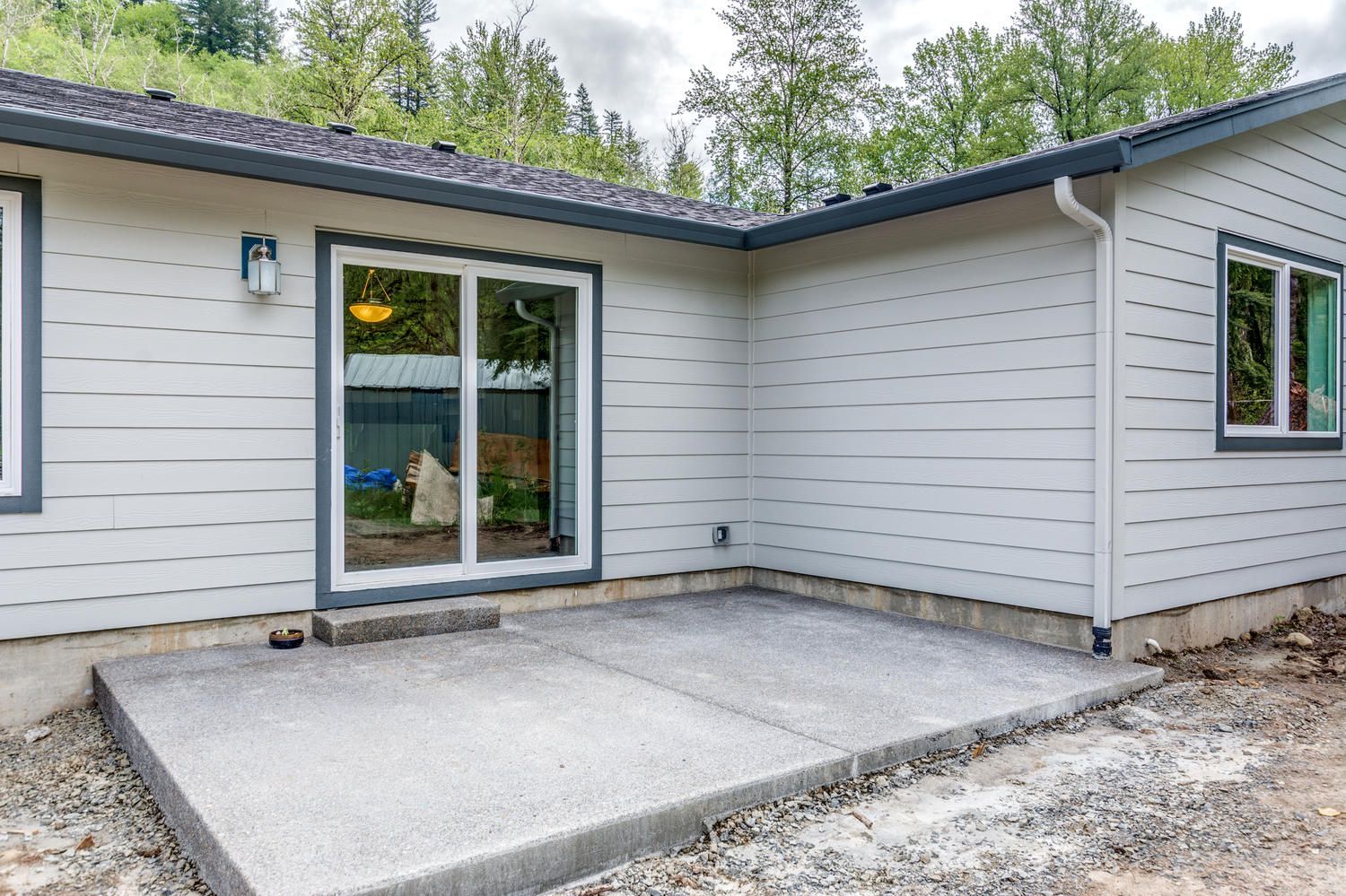 A white house with a concrete patio in front of it.