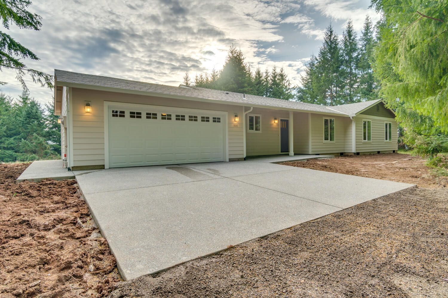 A white house with a concrete driveway in front of it