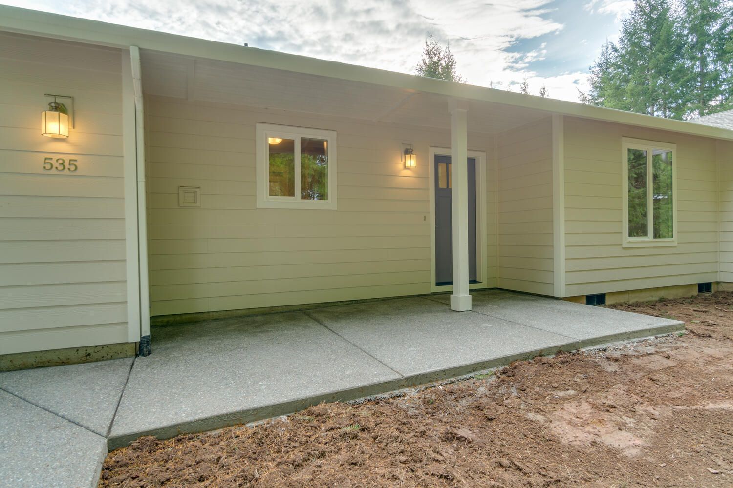 The front of a house with a porch and a concrete walkway.