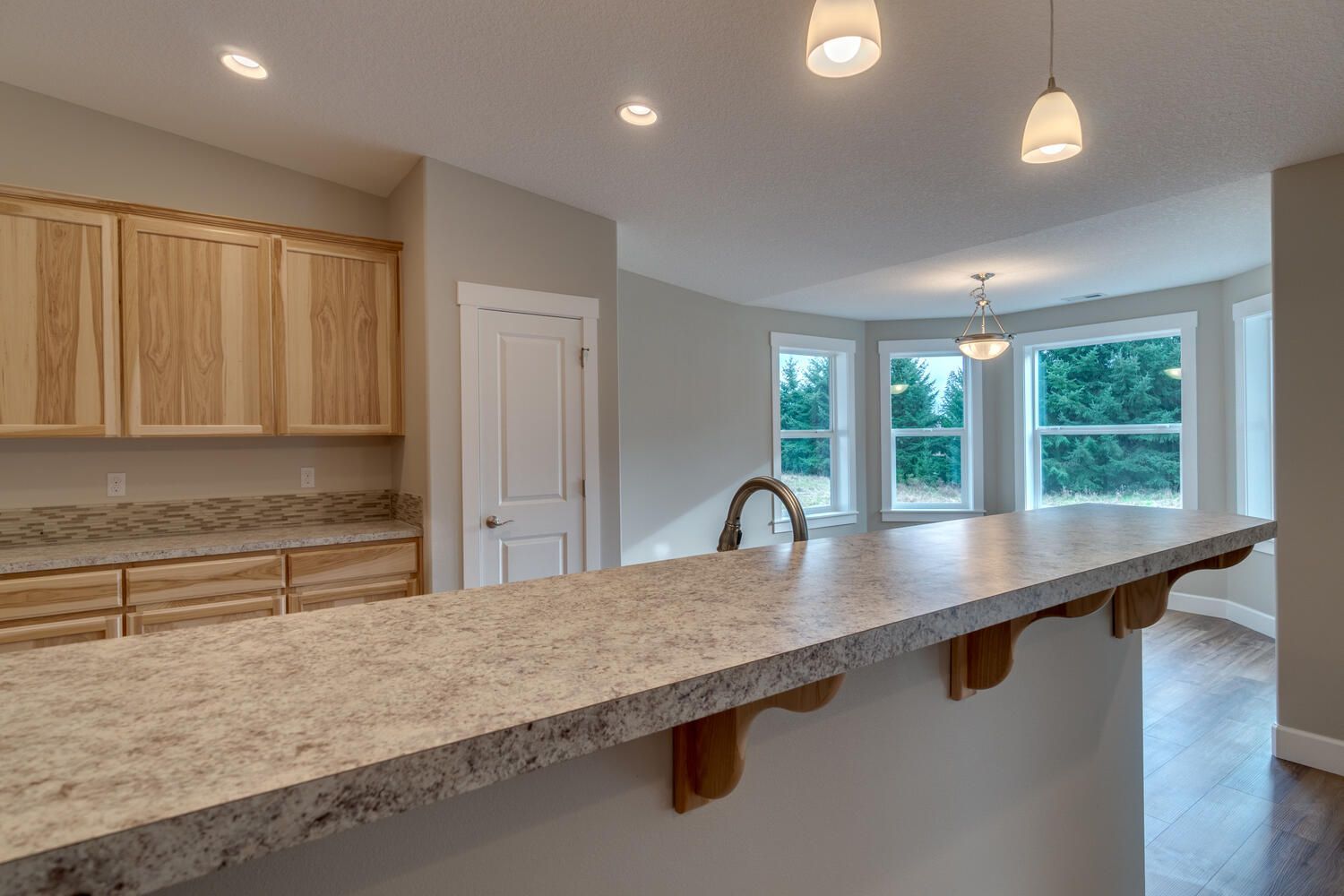 A kitchen with a large granite counter top and wooden cabinets.