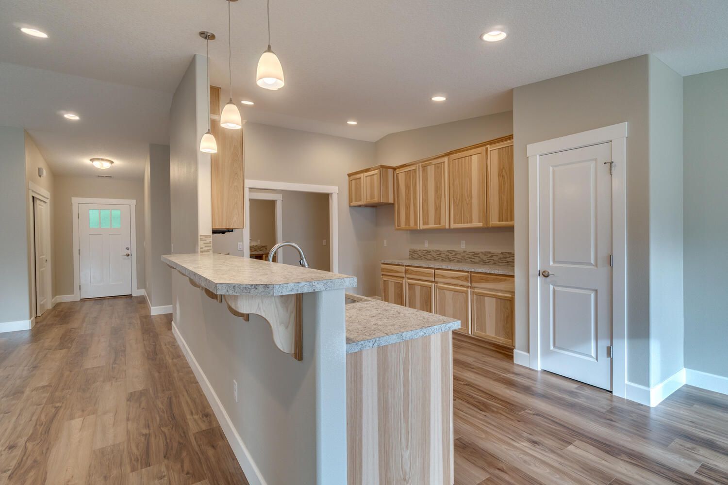 A kitchen with wooden cabinets , granite counter tops , and hardwood floors.