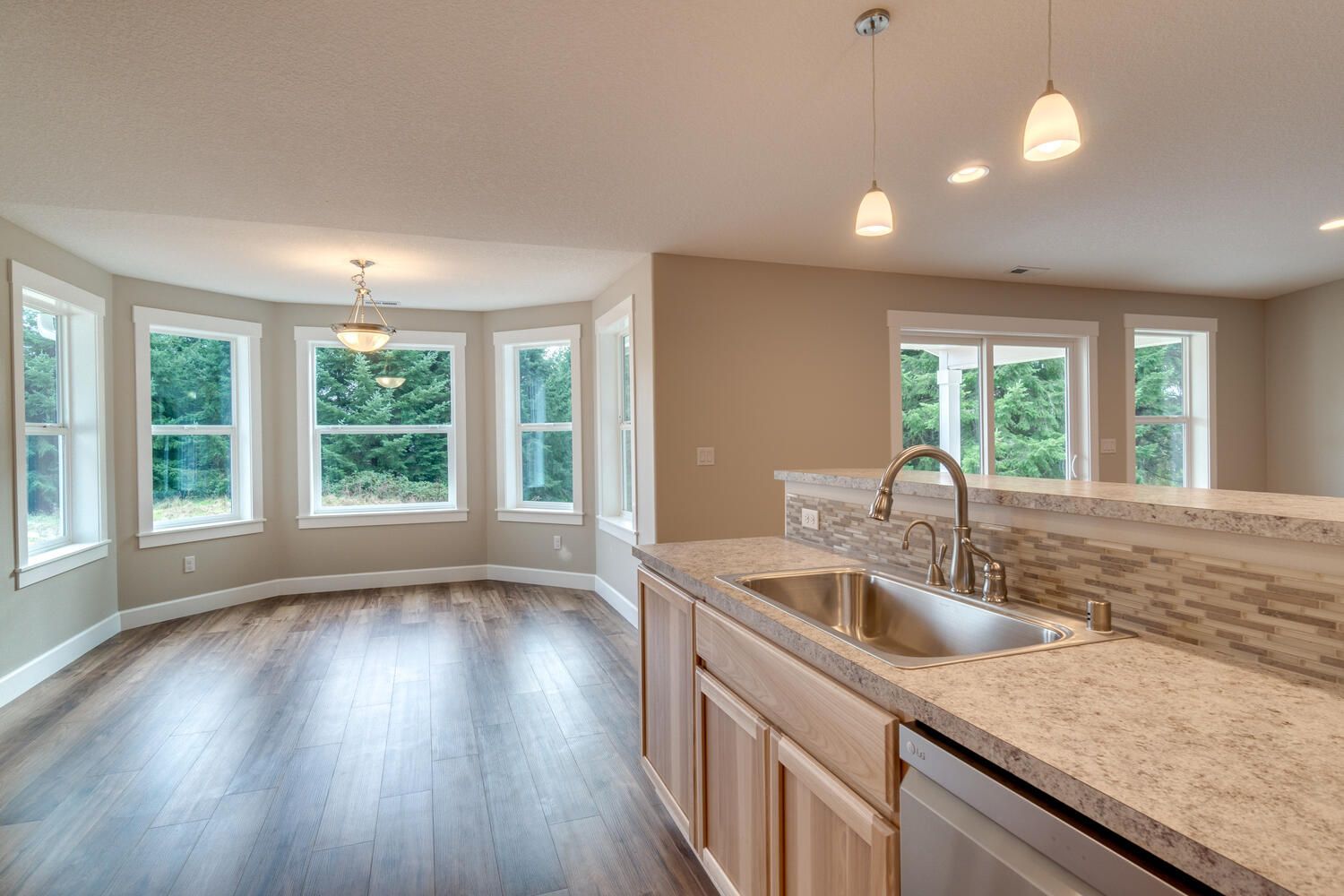 A kitchen with a sink and granite counter tops in a house.