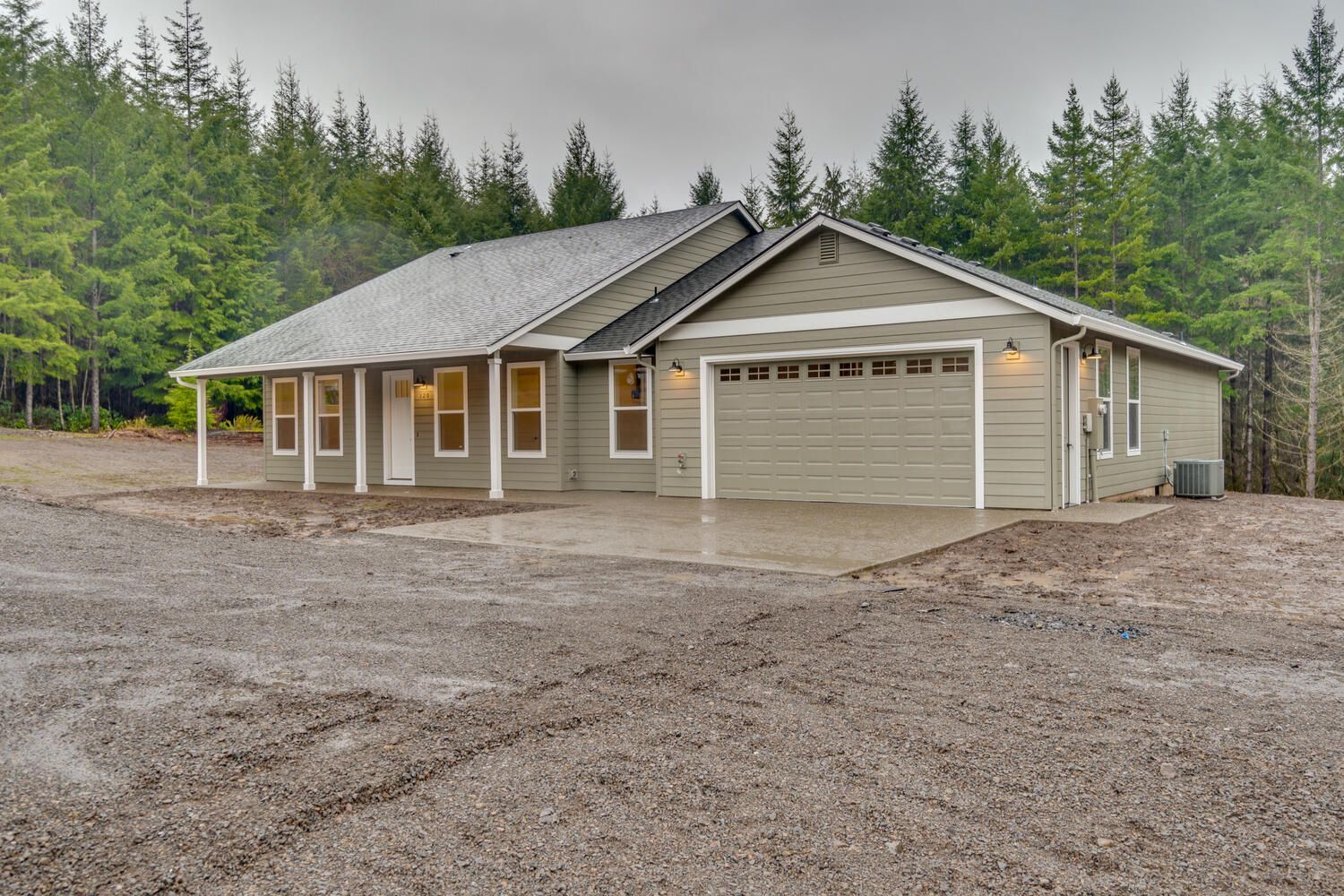 A house with a garage is surrounded by trees